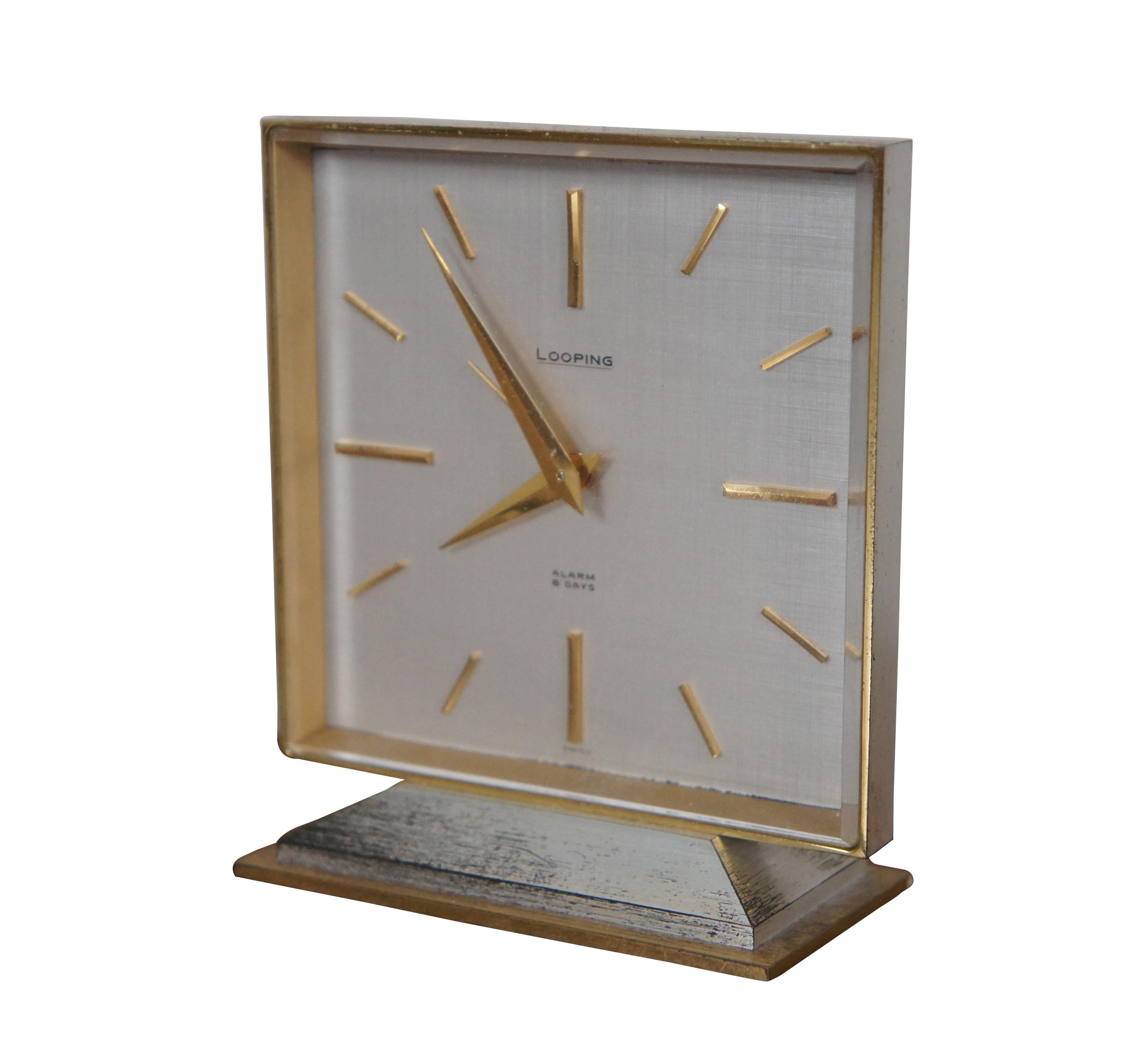 Mid century Looping Swiss 8 day alarm clock featuring 7 jewel movement and gilded brass case with glass.  Circa 1950s.

