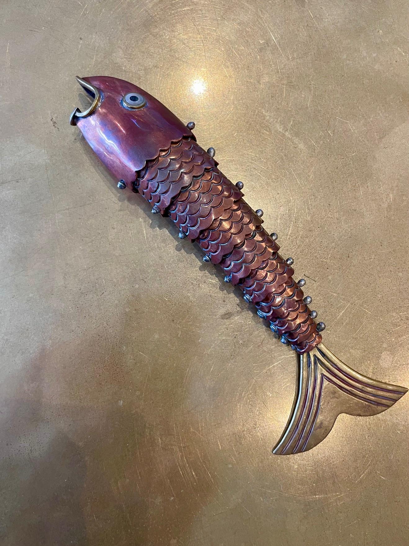 We love artistic mastery ​o​f this Los Castillo vintage​ metal fish bottle opener​. A magnificent blend of brass and copper, this articulated fish​ is not only a functional tool but also a captivating piece of art. Each shimmer of the of the rich