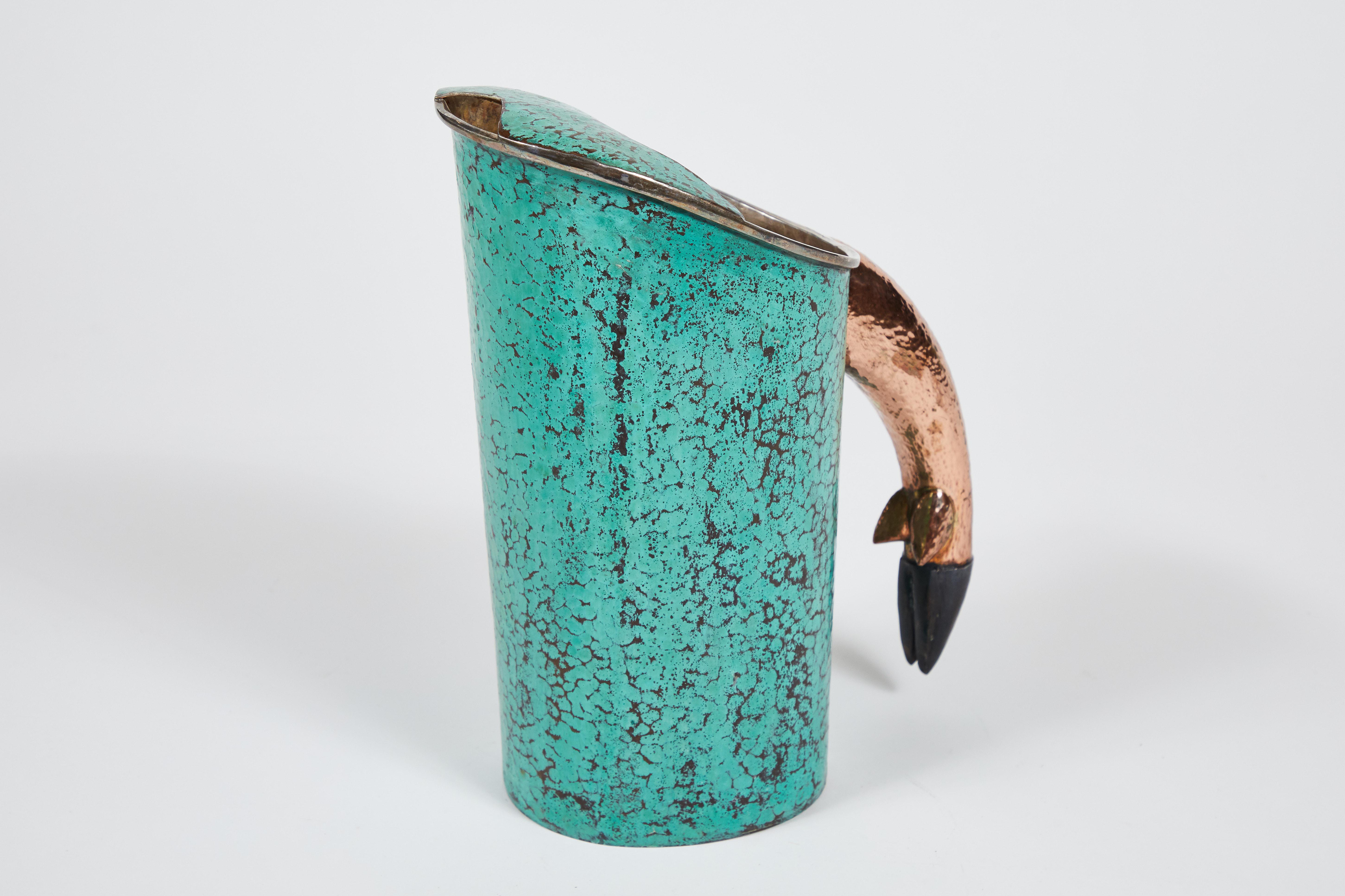 Midcentury Los Castillo Taxco hammered alpaca and copper pitcher with deer hoof handle detail - Made in Mexico. 

Hammered alpaca body has a beautiful turquoise patina and hammered copper handle is in the shape of a deer hoof.

Stamped.