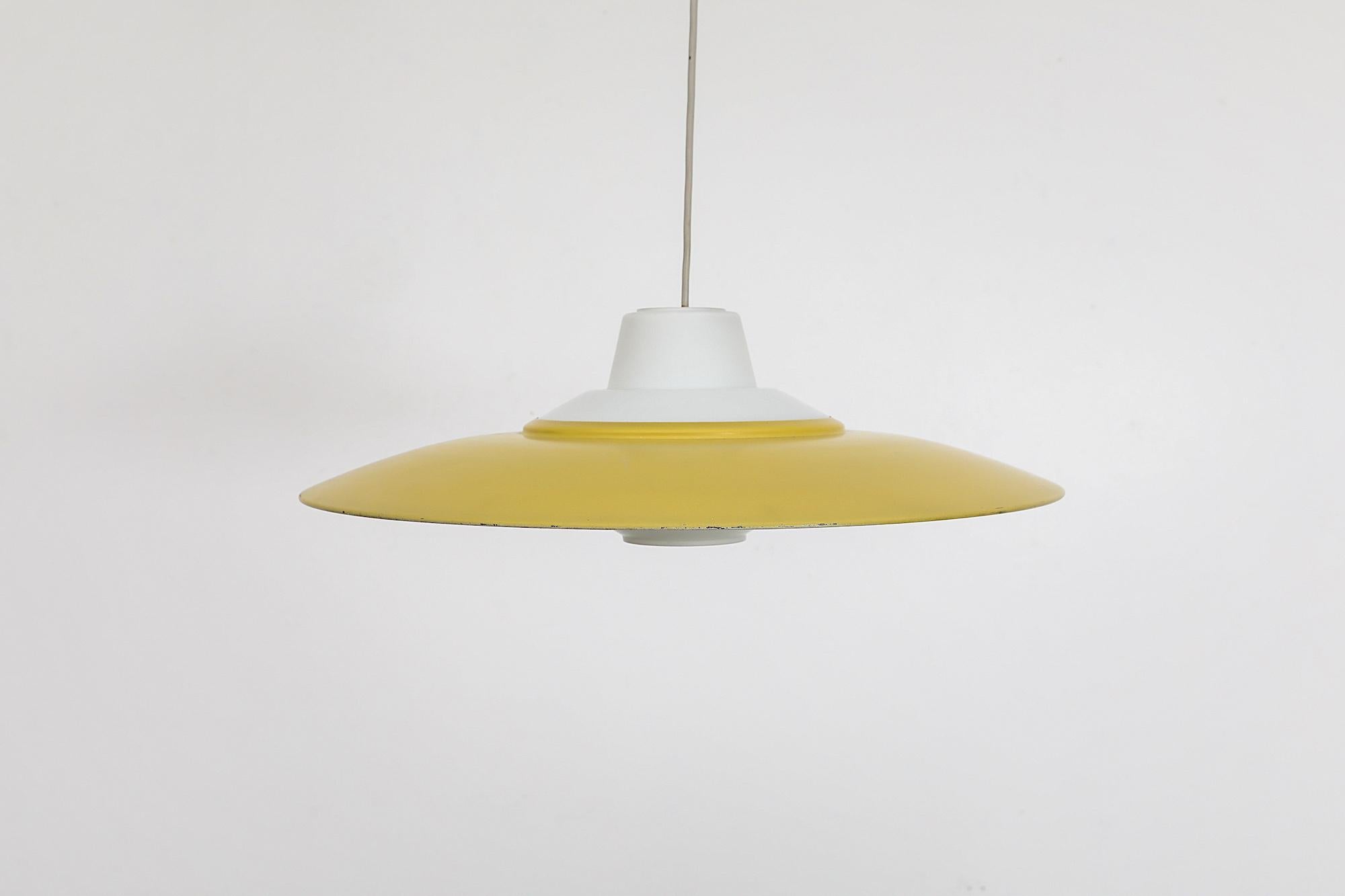 Mid-Century Louis Kalff attributed ceiling pendant for Philips. Kalff was the main designer during Philips' mid century years and left an indelible mark on the company and on Dutch design The pendant has an opal white glass base with yellow enameled
