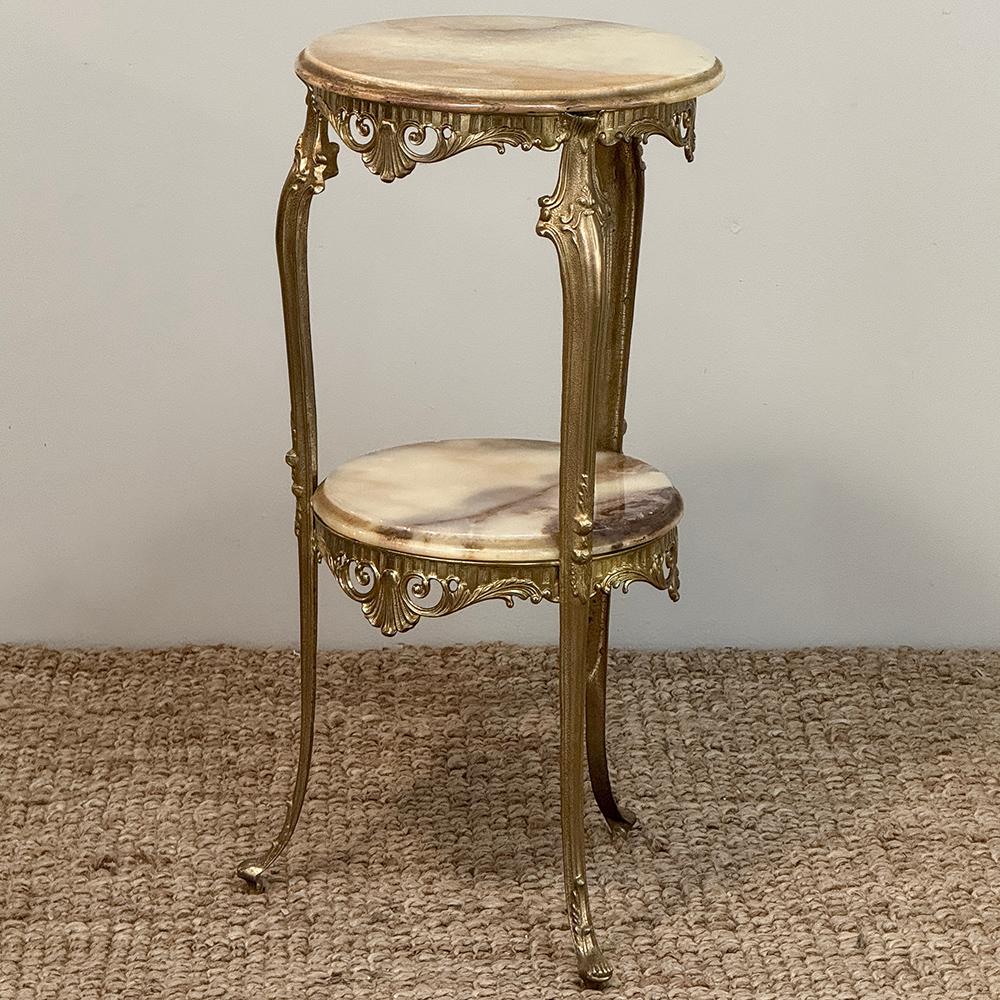 Ce guéridon en laiton et onyx de style Louis XIV du milieu du siècle sera le support idéal pour votre statue, votre vase ou votre objet d'art.  Fabriqué en laiton massif moulé avec des détails complexes à la manière de Louis XIV, il présente un