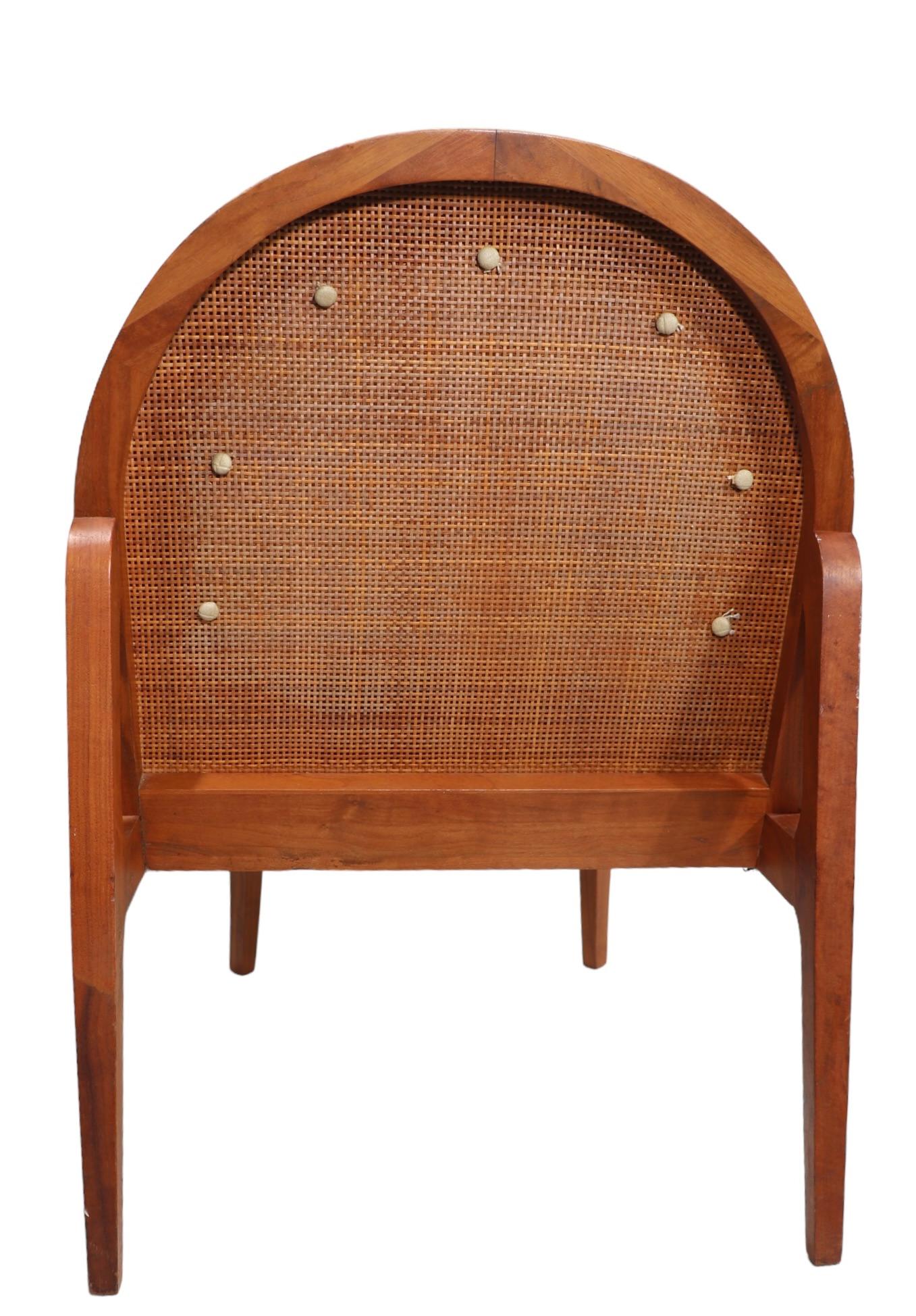 Exceptional sophisticated Mid Century lounge chair in very good, clean, original, ready to use condition. The chair features a caned back which  supports the upholstered vinyl cushion, a walnut frame with an exposed architectural form structure.
