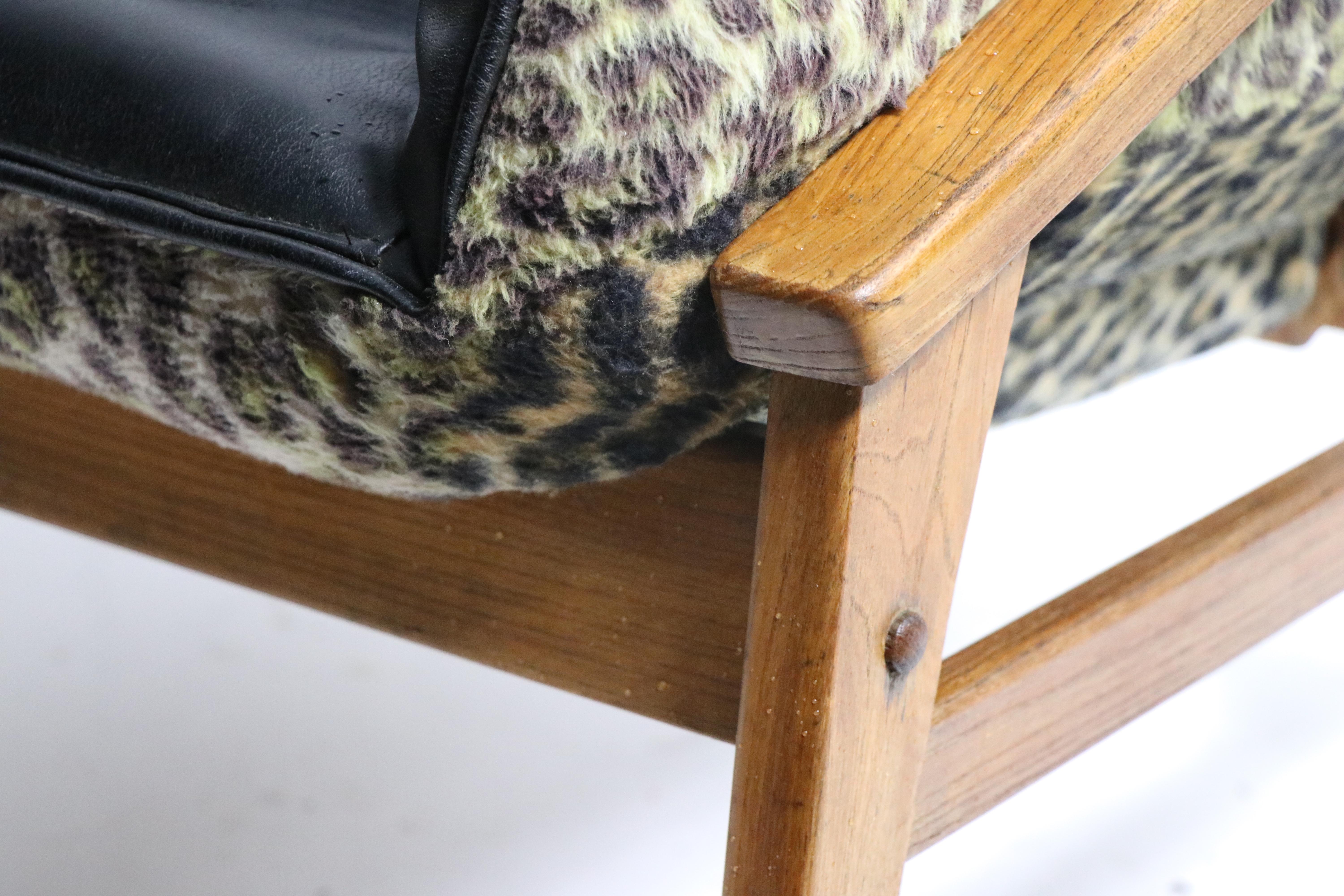 Chic mid century lounge chair, attributed to Murphy Miller. The chair features an architectural exposed oak frame, with a sexy black vinyl and faux cheetah upholstered bucket seat. This example is in very fine, original, clean and ready to use