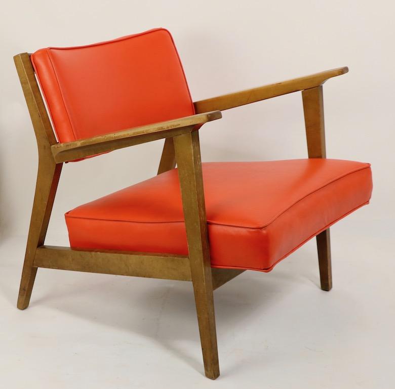 Stylish Mid Century lounge chair design after Jens Risom, attributed to Gunlocke. The chair has orange vinyl cushions, and a solid wood (probably maple) frame. The chair is solid and sturdy however the wood finish shows cosmetic wear, please see
