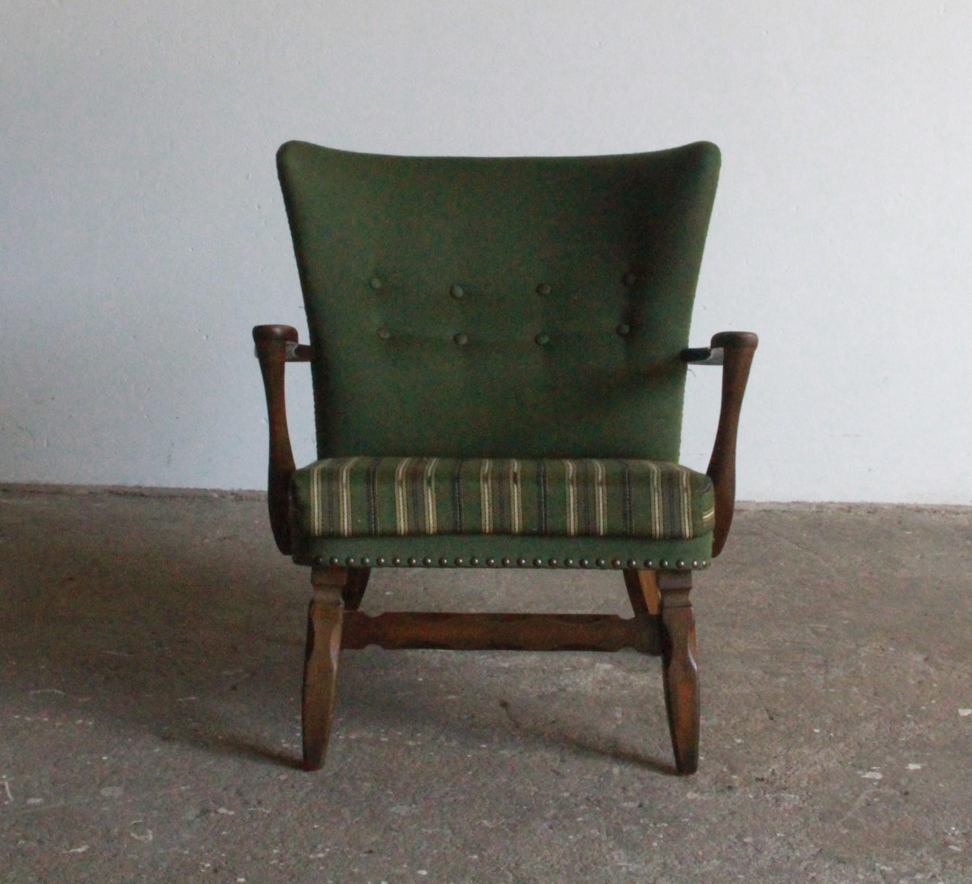 Cette chaise de salon moderne danoise compacte en chêne teinté foncé, fait écho au style emblématique des années 1960 de Viggo Boesen. Cette chaise allie forme et fonction avec sa taille modeste, son dossier haut et son assise basse, rehaussée par