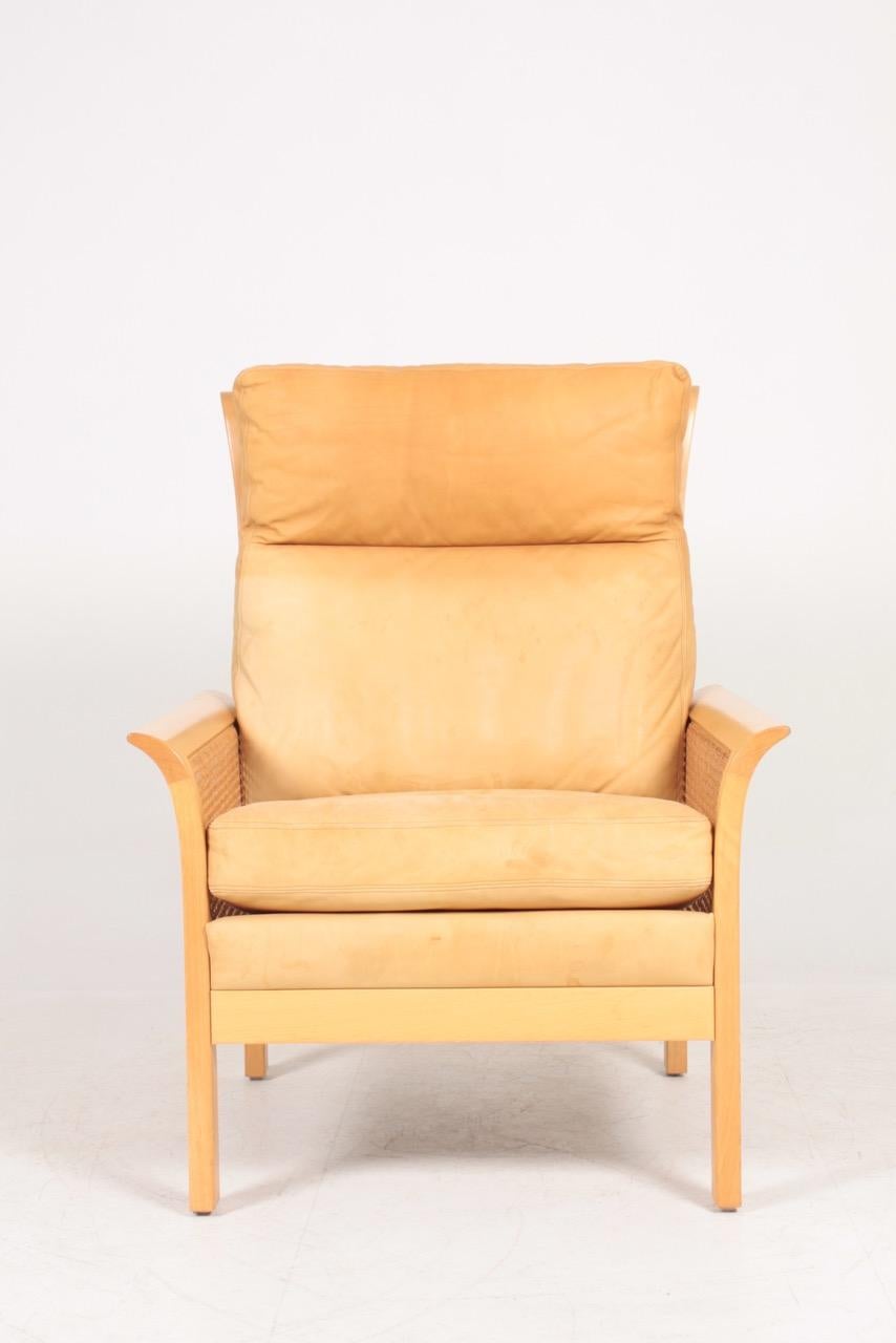 Scandinavian Modern Midcentury Lounge Chair in Patinated Leather and Cane Designed by Arne Norell