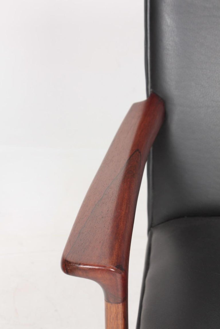 Elegant lounge chair in rosewood and black leather designed by Maa. Ole Wanscher and made by AJ Iversen cabinet makers Copenhagen. Great condition.