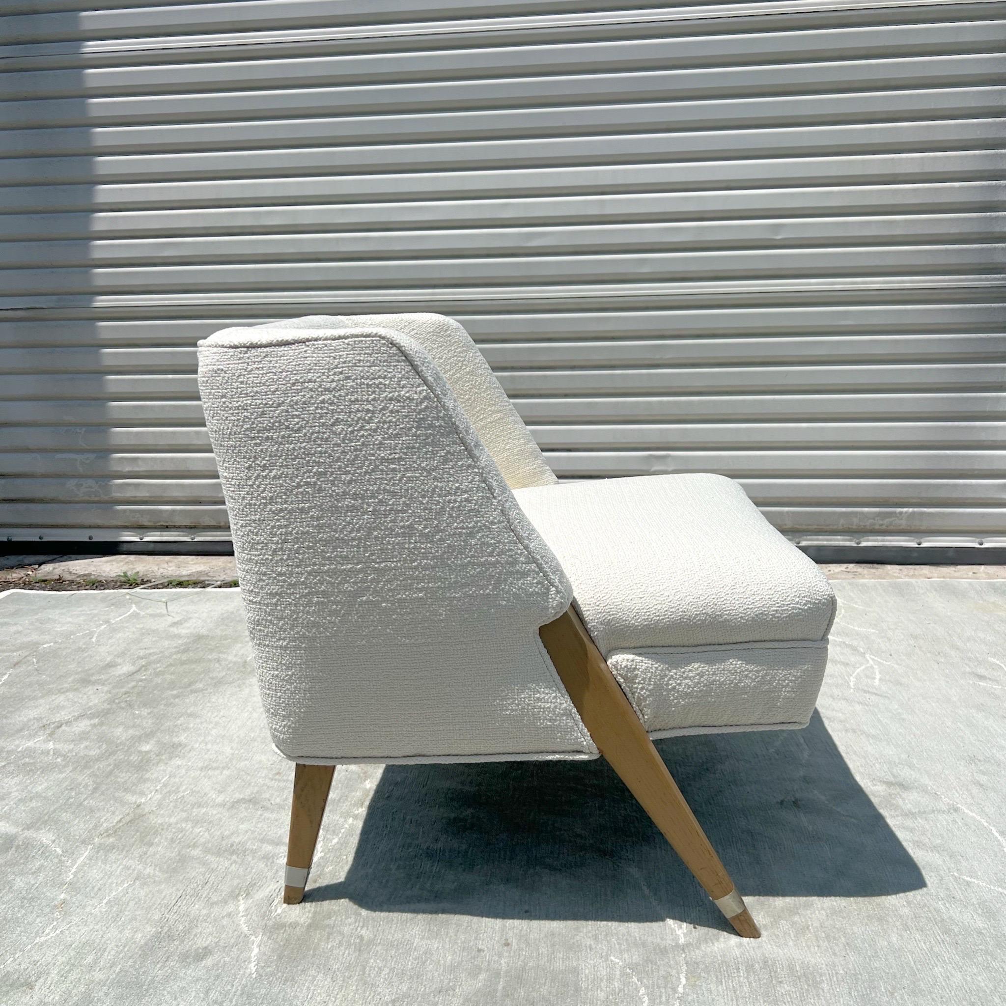 A rare sculptural lounge chair in the manner of Gio Ponti circa 1950s.   Squared upholstered seat with exposed angled legs and aluminum banding detail.  New Schumacher white boucle upholstery.