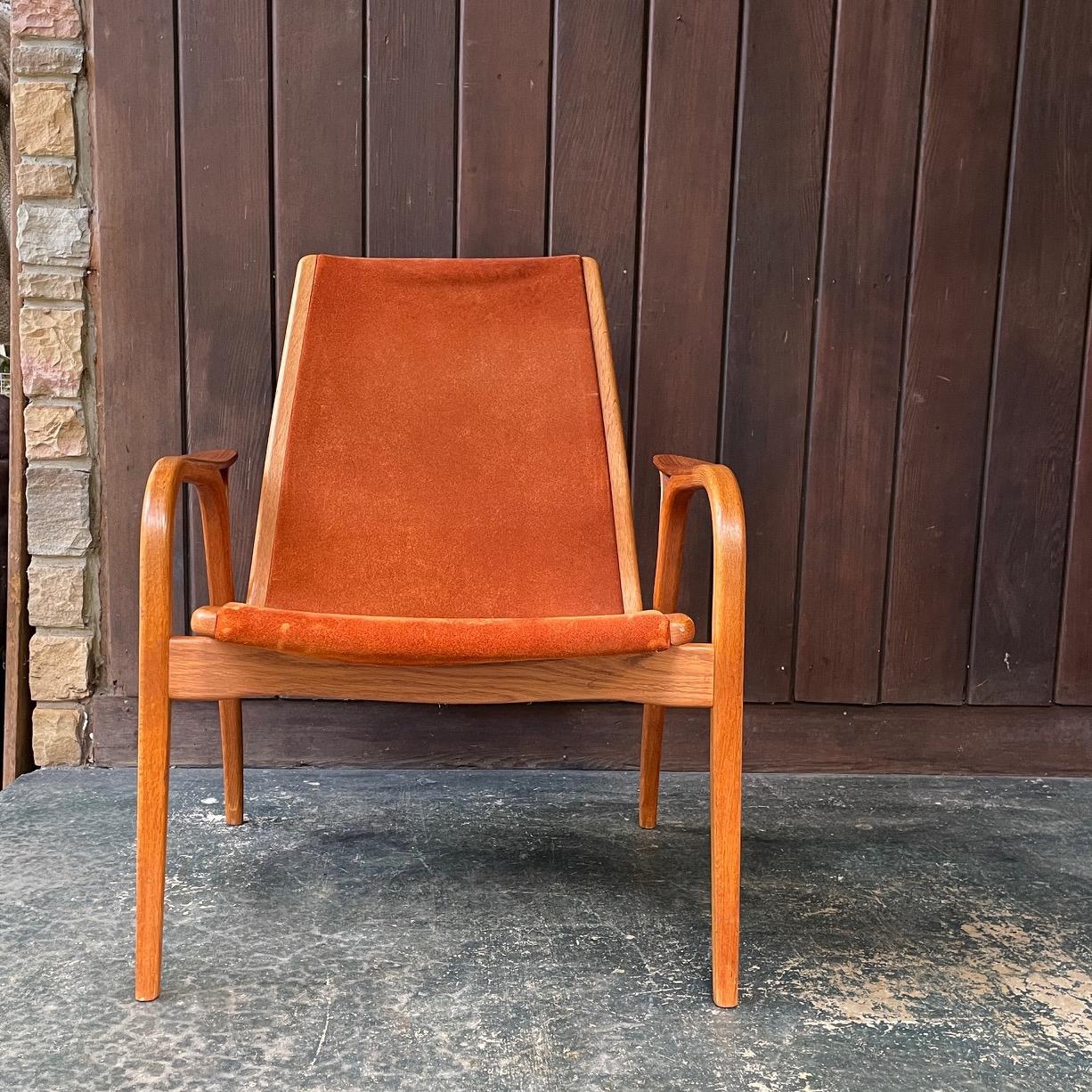 Chaise Yngve Ekstrom à dossier bas de la série Lamino en cuir brun clair chaud. Structure en chêne courbé avec accoudoirs sculpturaux incrustés de teck.

L 27,25 x P 28,25 x Siège H 15,75 / Accoudoir H 20,25 / Dossier H 31 in
