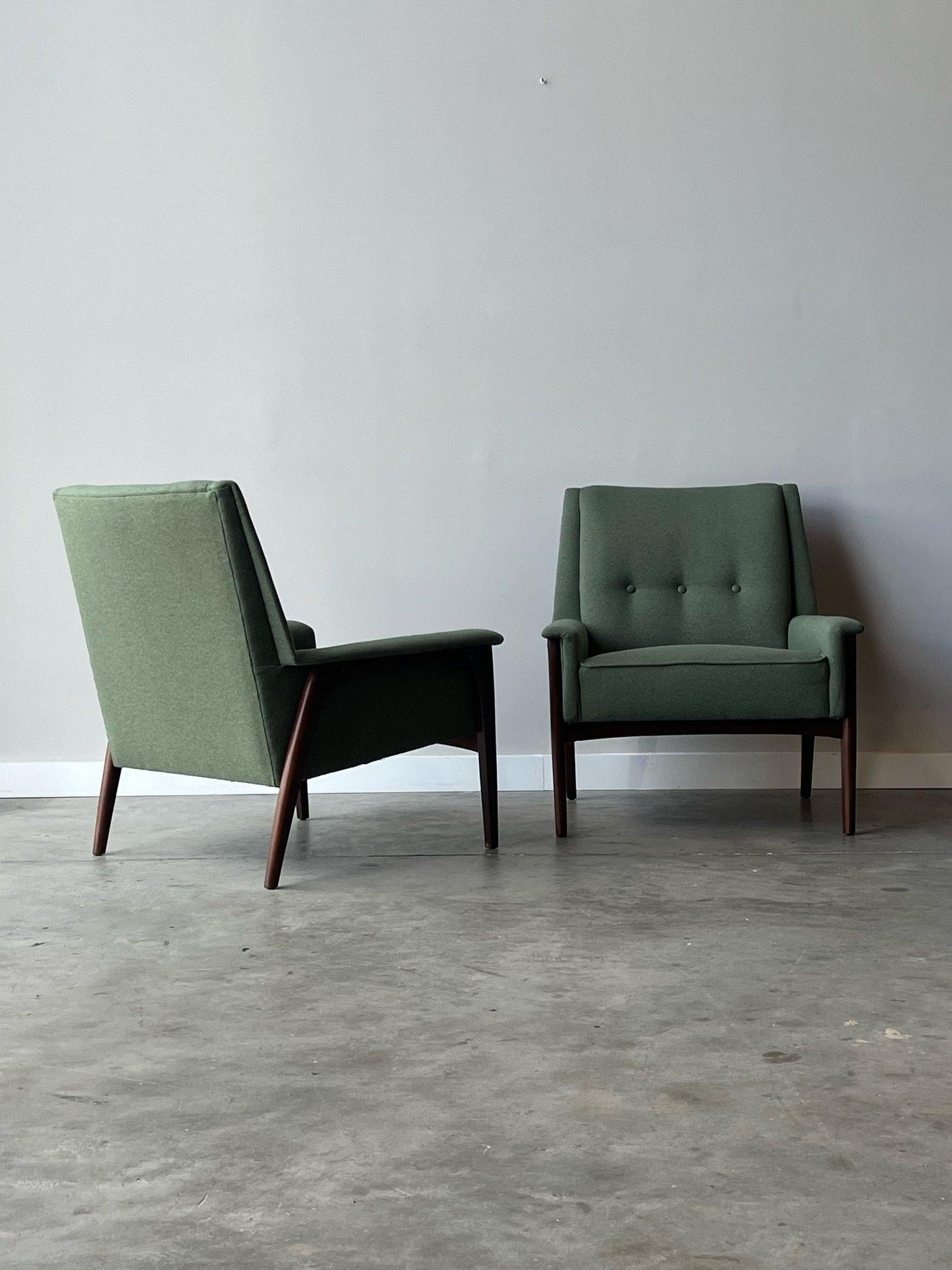 Mid-century  lounge chairs manufactured by Koehler, circa 1950s. This pair features a vibrant earthy green upholstered body. Arched walnut legs frame the sides of the chairs. The legs add more earthy appeal, contrast against the fabric wonderfully,