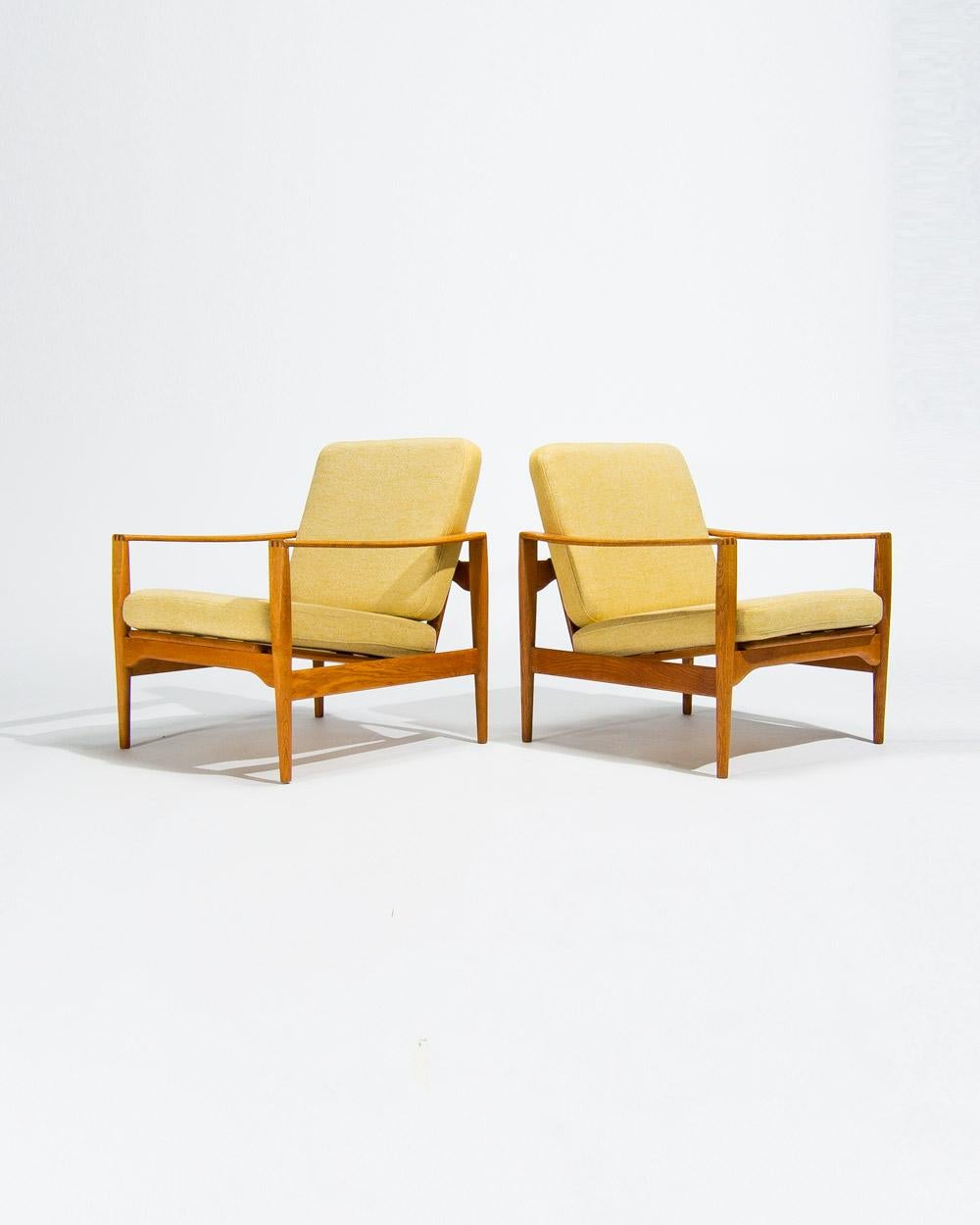 Mid century lounge chairs designed by Niels Koefoed in the 1950s, model Lars. This rare pair in solid oak features elegant brass back supports and beautifully crafted joints that highlight the quality of Danish craftsmanship. With their refined