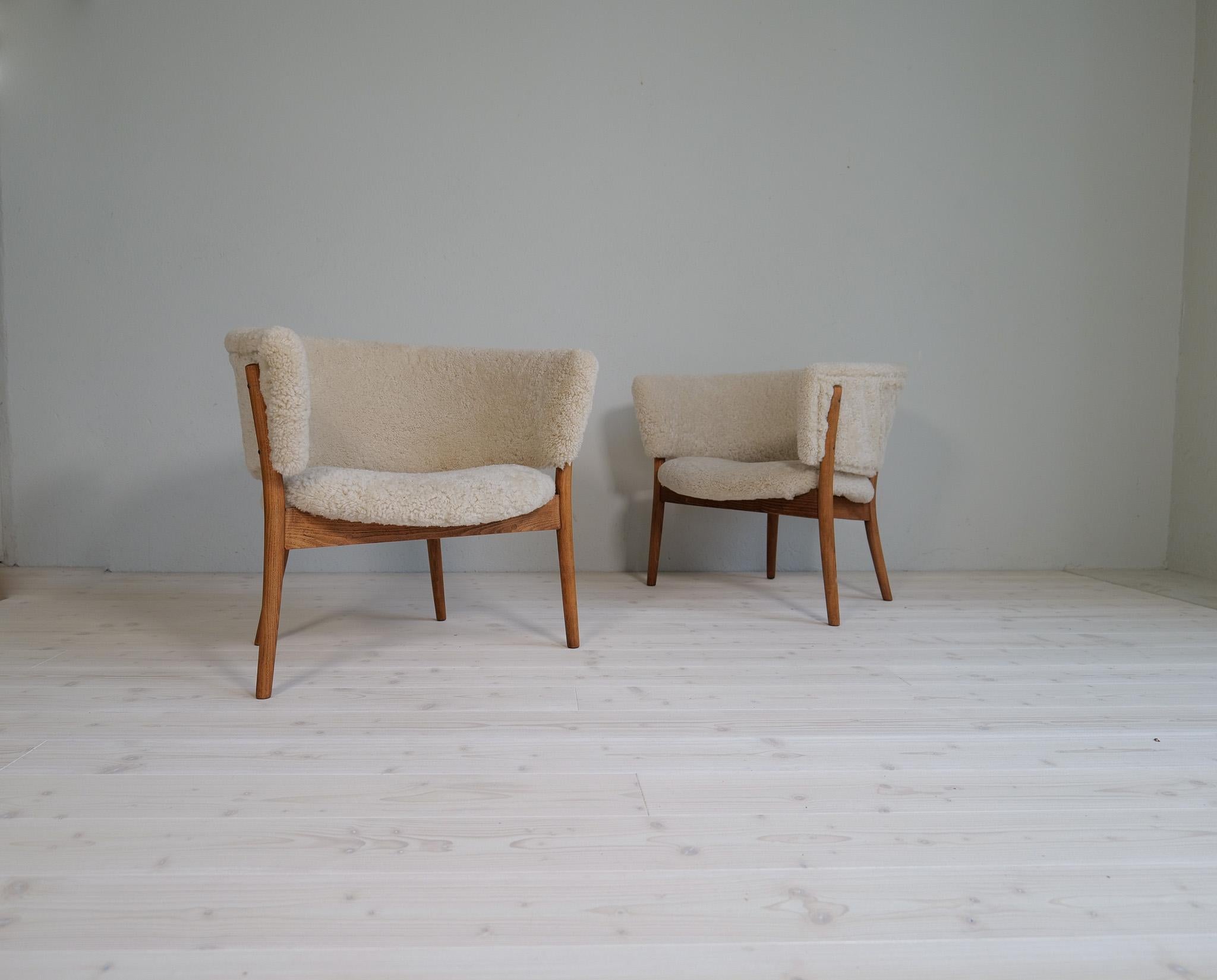 These two wonderfully crafted chairs were made in Sweden 1962 and design by Erik Wörts. The chairs made in stained birch and sheepskin has been redone both in the wooden part as well all new upholstery with quality sheepskin. The shearling is made