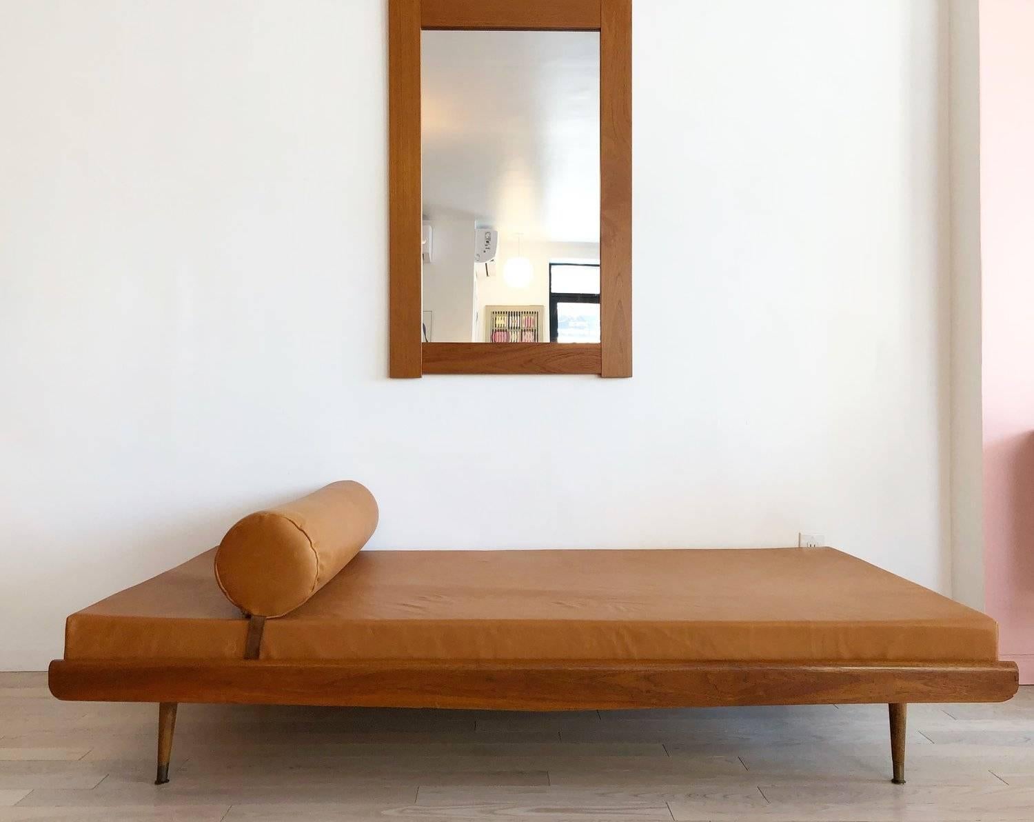 Stunning midcentury daybed in caramel colored buttery soft genuine leather upholstery. New memory foam cushions. Removable bolster pillow with strap to keep secured in place. Original 1960s peg legs, can be placed straight up and down or angled.