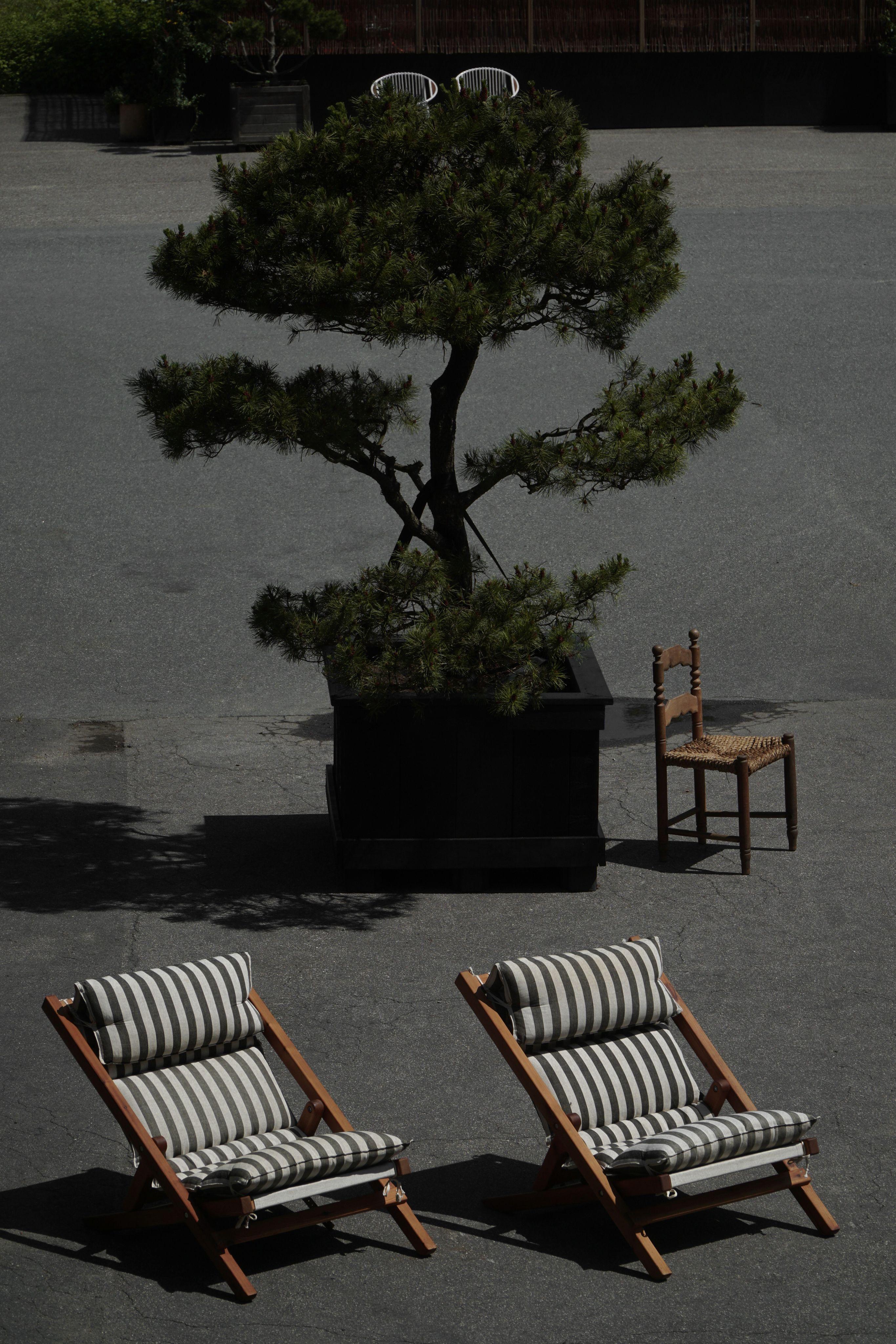 A refined pair of sun deck lounge chairs crafted from solid pine, featuring strong leather strap detailing and built for lasting comfort. The seats are made with high-quality, striped white cotton canvas that is both soft to the touch and remarkably