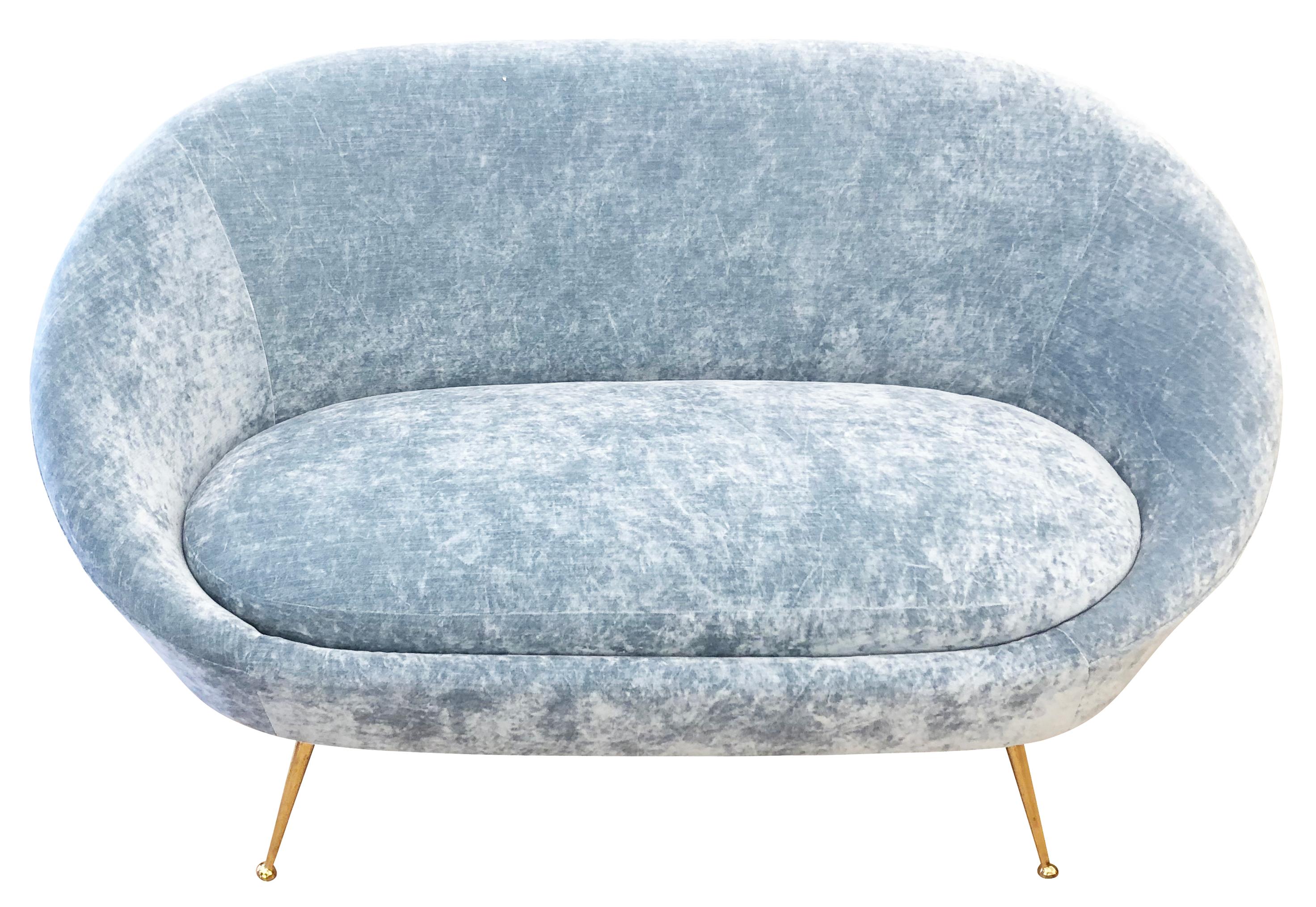 Beautifully designed and balanced midcentury loveseat in the manner of Ico Parisi. Its curved lines and tapered brass legs give it a sensual and modern feel. Has been re-upholstered in light blue velvet.

Condition: Re-upholstered. Legs show minor