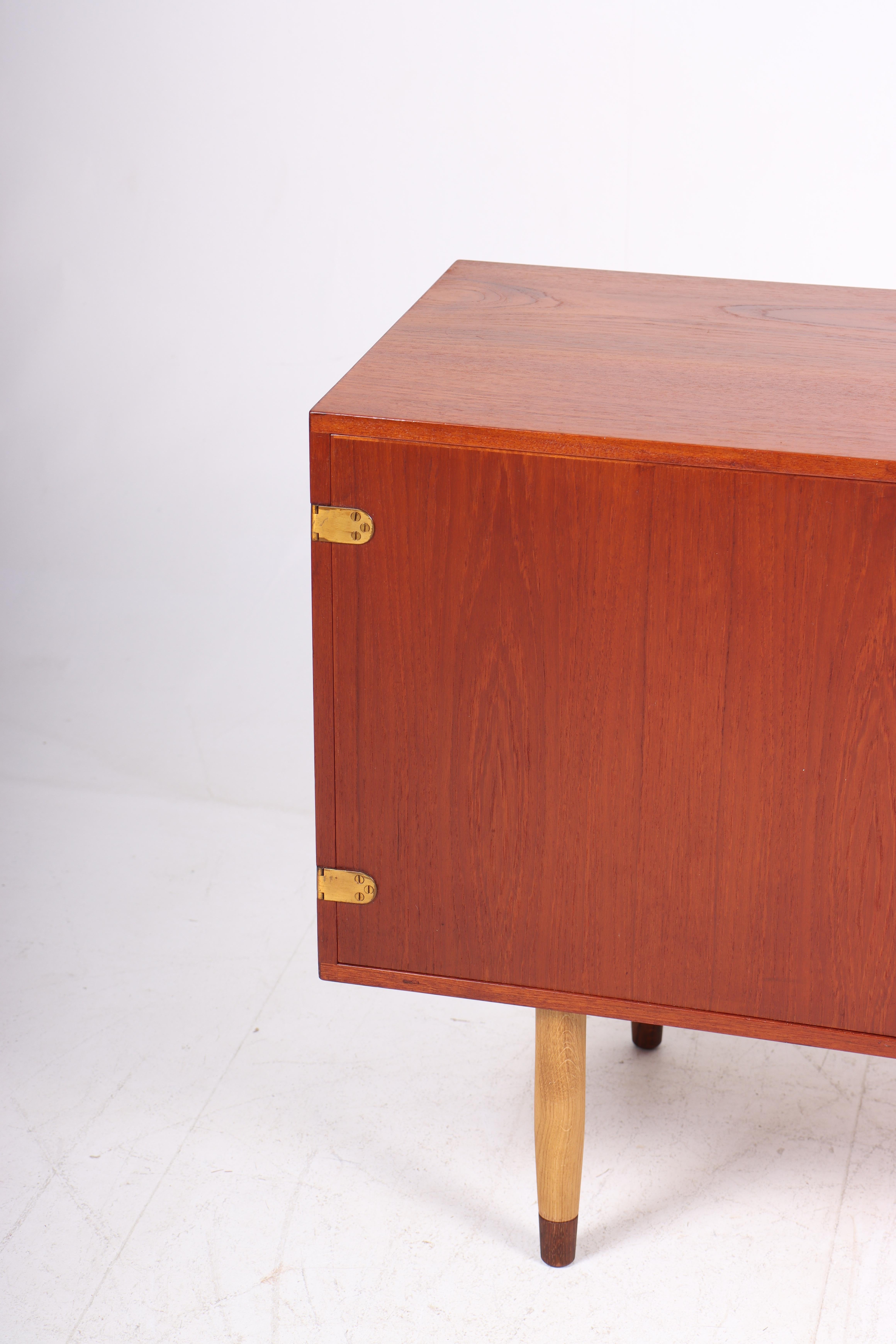 Cabinet in teak and oak with brass hardware. Designed and made in Denmark in the 1960s. Great condition.