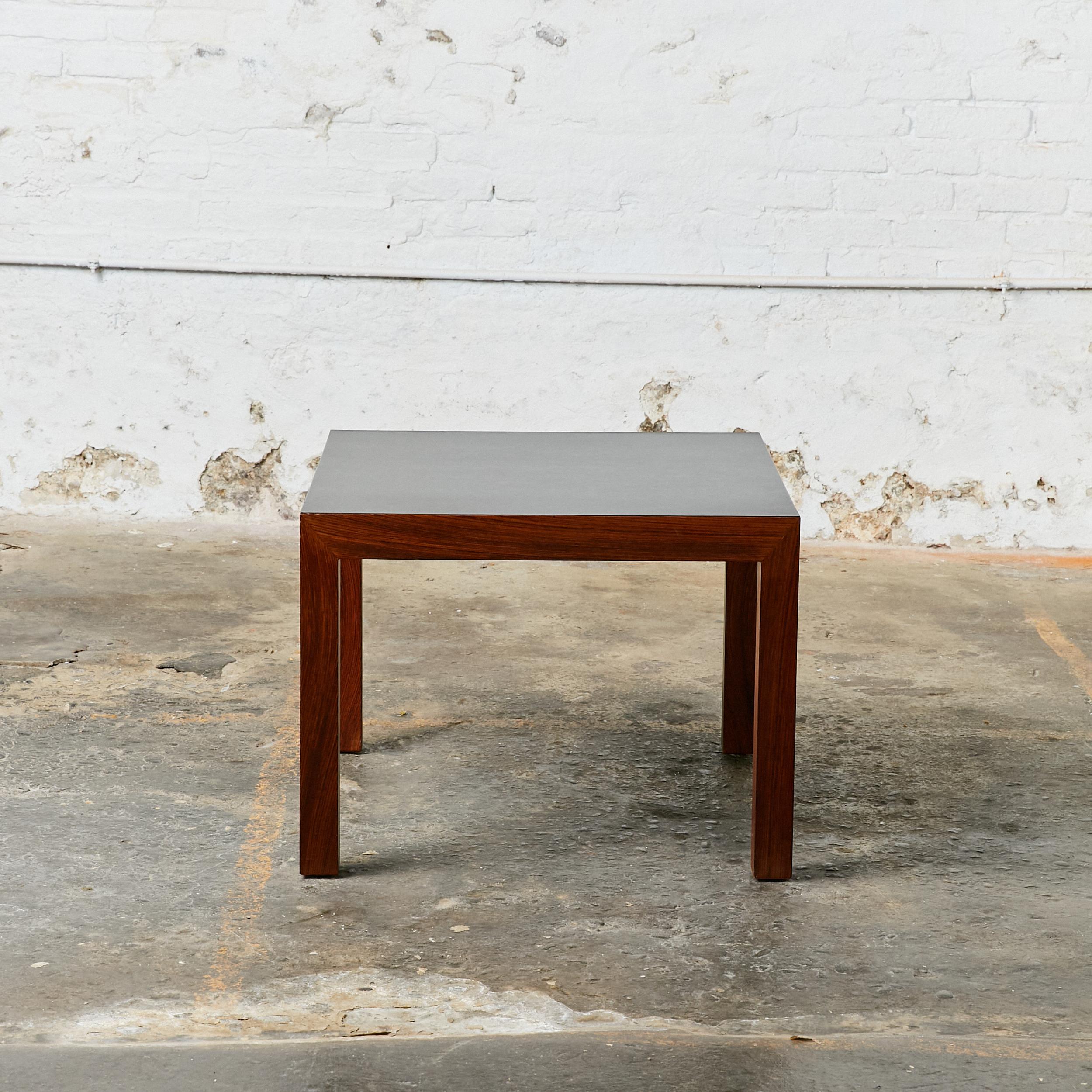 Mid-Century low side table. Legs and top frame finished in dark brown stained wood and black laminated top.