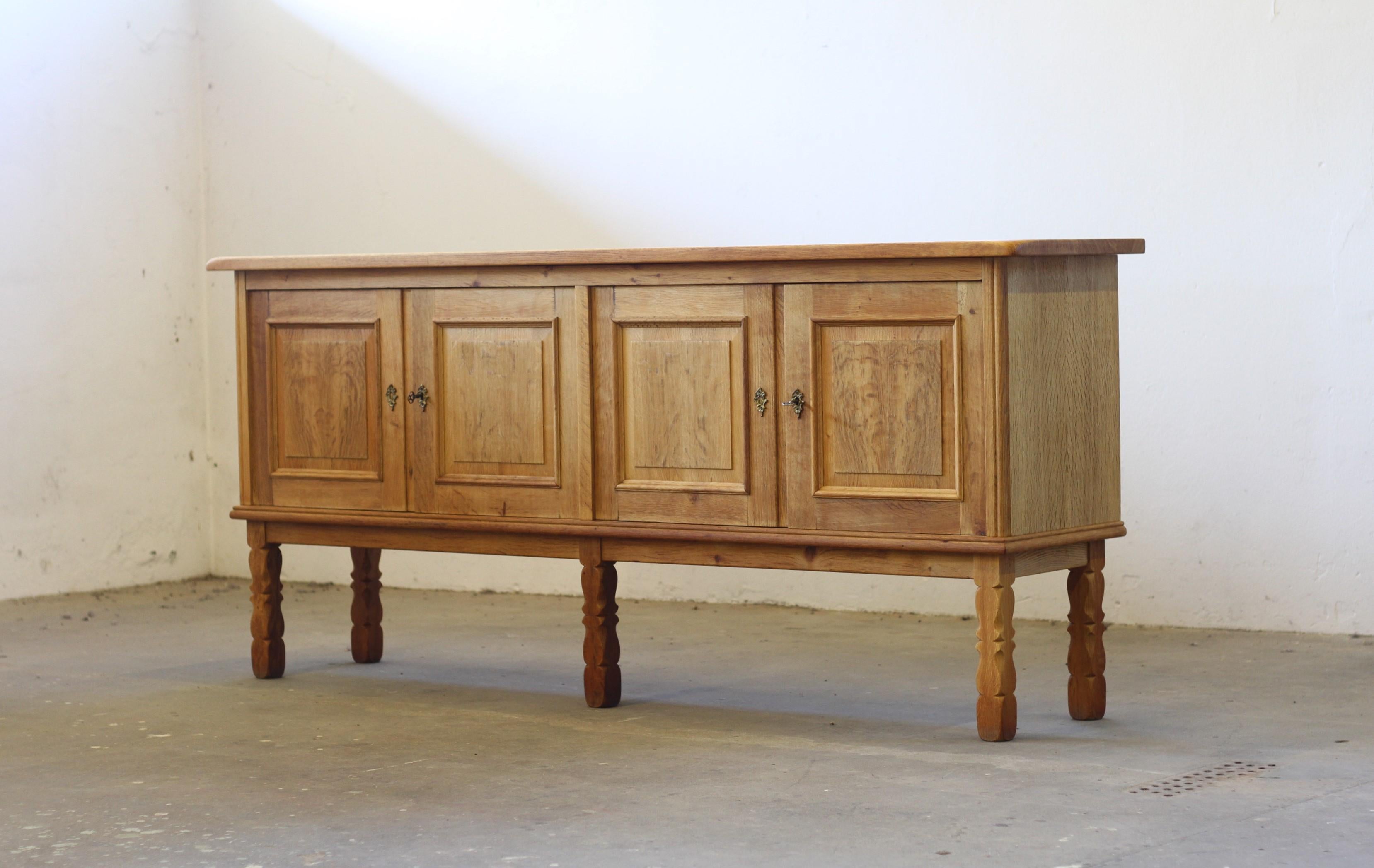 A beautiful and wellkept furniture in massiv oak in the style of Henning Kjærnulf. Even though that the cabinet is big and heavy, it still feels slim and elegant. The squared dimensions of the item make it carm and warm in appearance. The 5 legs