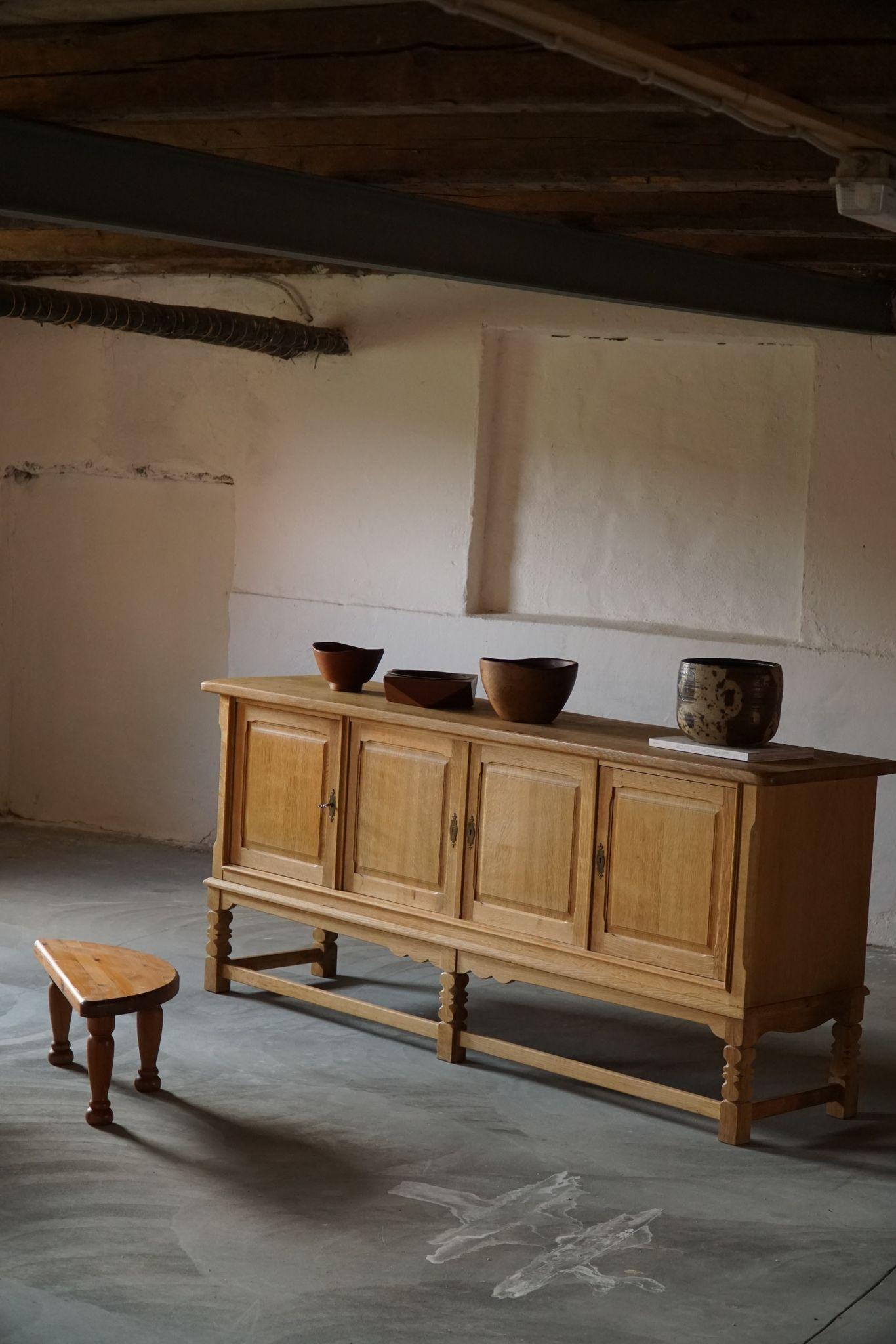 A sculptural low rectangular classic sideboard / cabinet in solid oak with plenty of storage and a nice carved front design. Made by a Danish cabinetmaker in ca 1960s. 
This piece is in a good vintage condition.

This nice brutalist sideboard