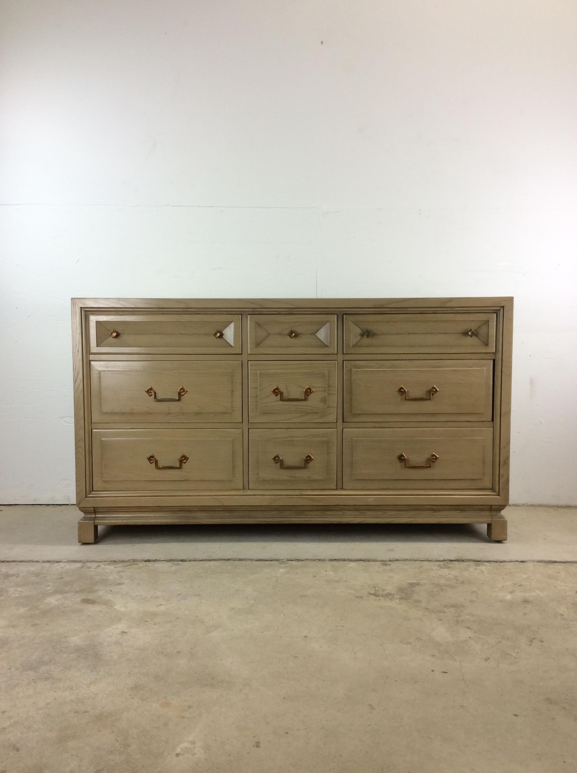 This mid century modern lowboy dresser features hardwood construction, oak veneer with original limed oak finish, nine dovetailed drawers with copper accented hardware, and stretcher base.  Matching pair of nightstands, writing desk, and highboy