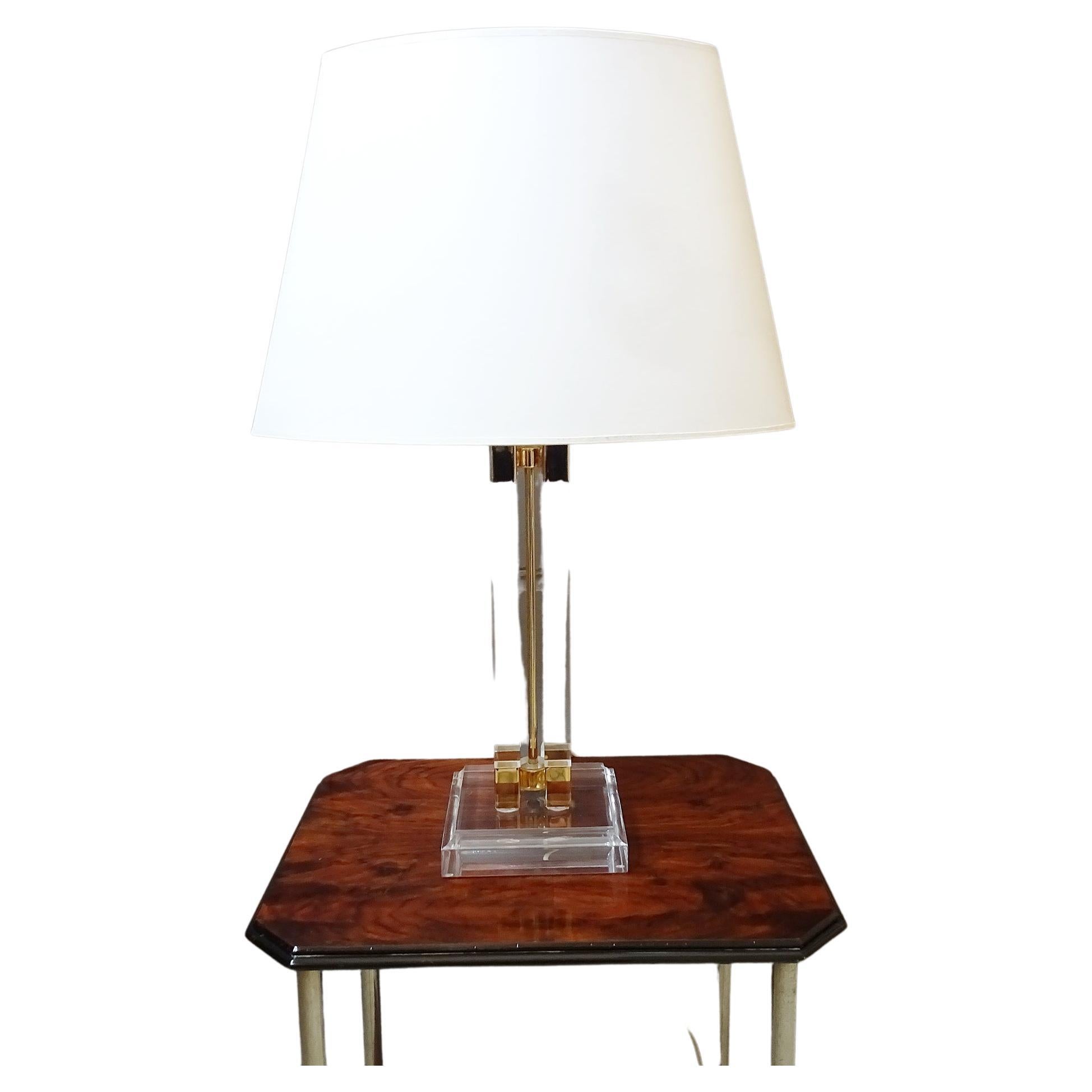 Lucite table lamp from the 1970s. Shapely large body made of acrylic glass with details made of golden metal with a large lampshade in cream color. Noble and timeless design, perfect for the Hollywood Regency style.

The original shade has