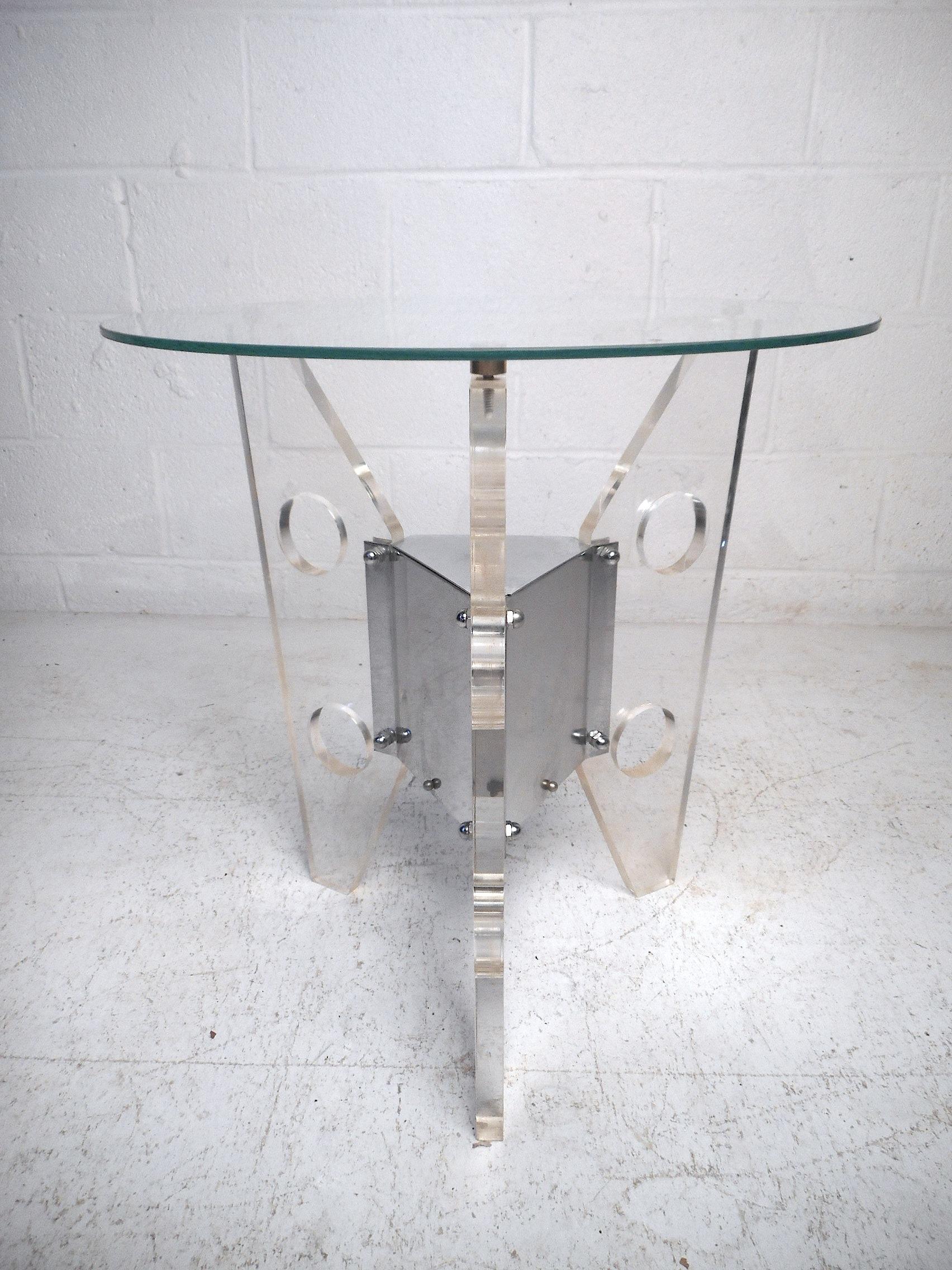 This unusual midcentury end table features a stylish three-piece Lucite base with a bold chrome centerpiece and a round bevelled glass tabletop. In the style of Charles Hollis Jones, this unique mid-century end table is sure to make an impression in