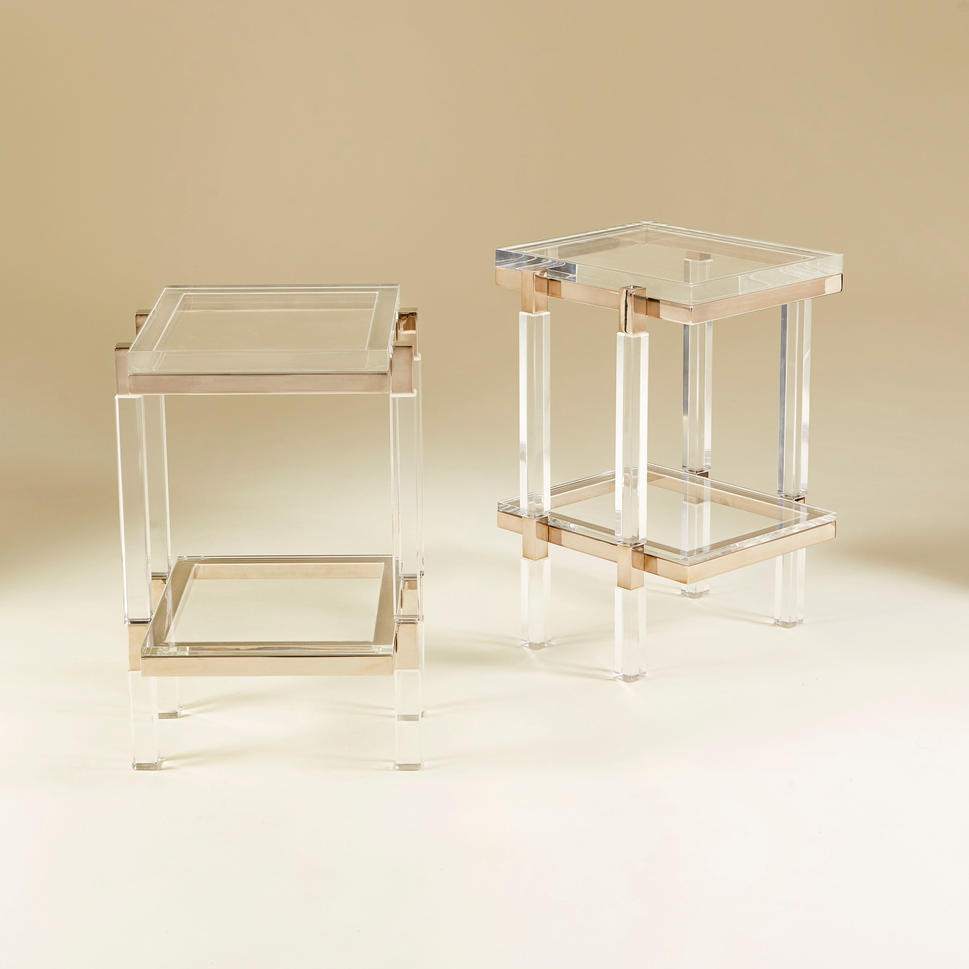Wonderful pair of two-tier side tables with thick Lucite shelves and chic polished nickel detail. Designed in the 1960s by Charles Hollis Jones as part of his Metric collection. Signed Charles Hollis Jones.

Charles Hollis Jones (born 1945) is an