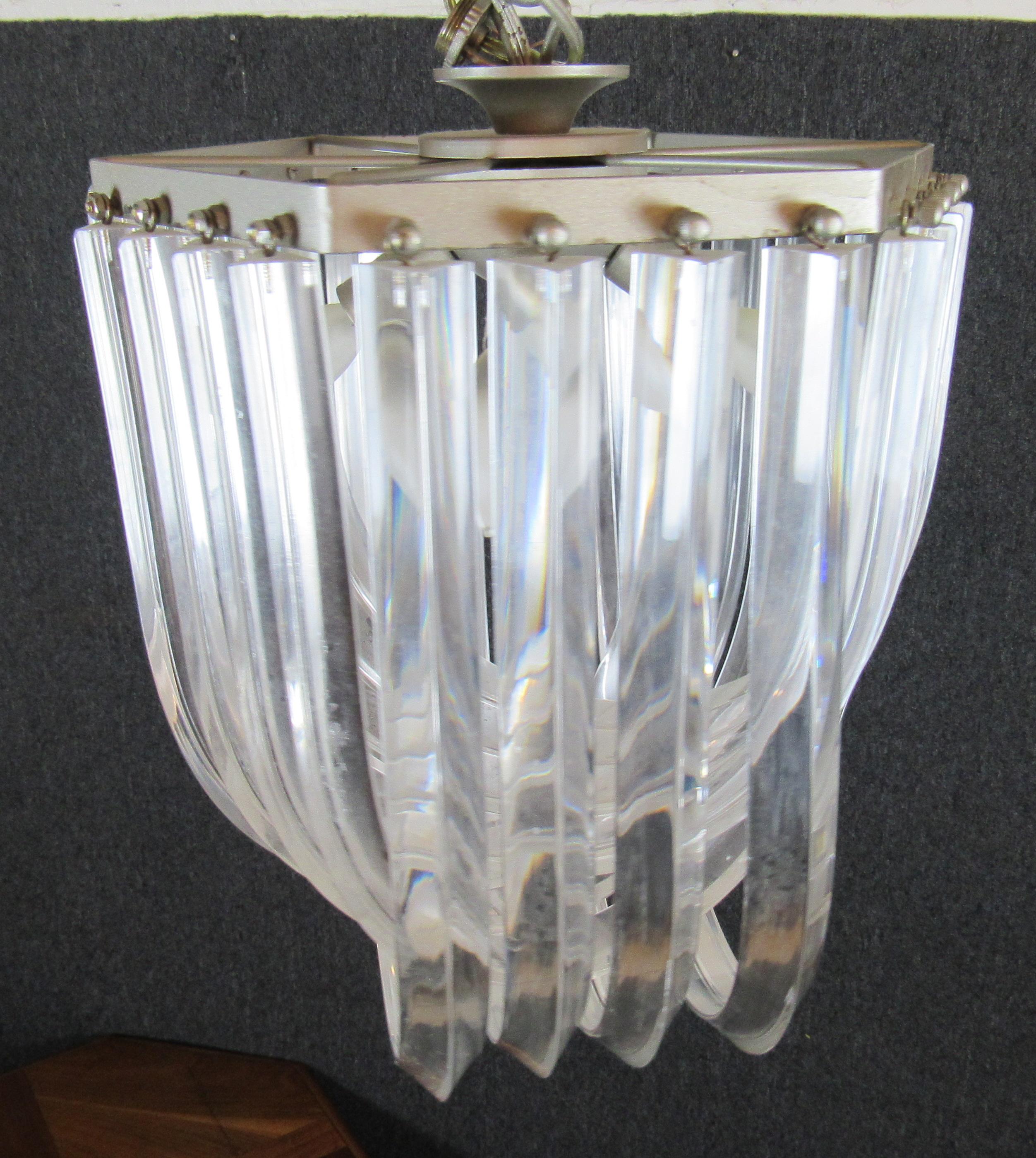 Vintage modern chandelier with banded lucite. Ribbon bands with a cascading style attached to a chrome frame.
Please confirm location.