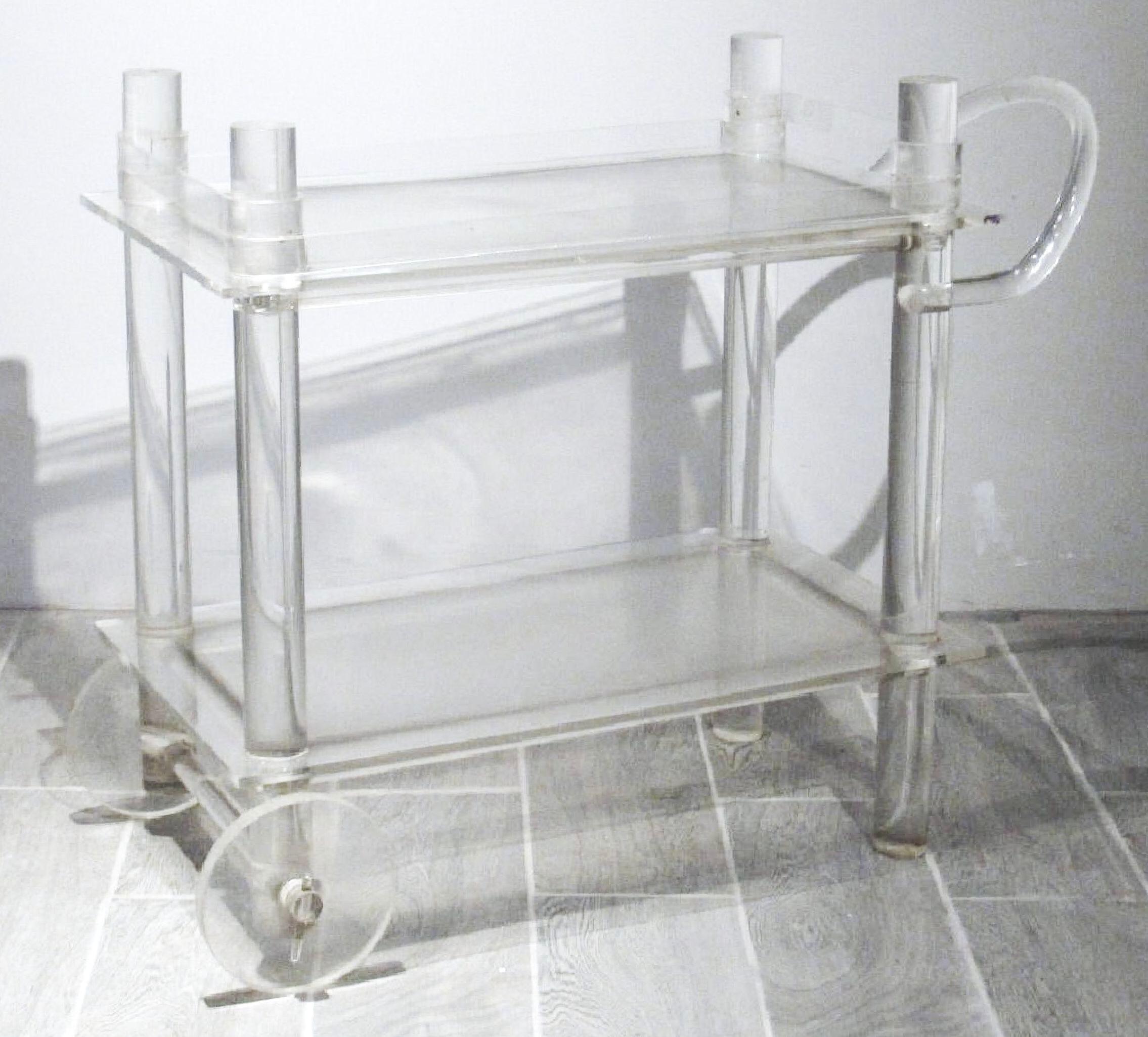 2 shelves (showing age) with top having removable gallery. Sculpted handle and tubular posts, wheels working. Measures: 37
