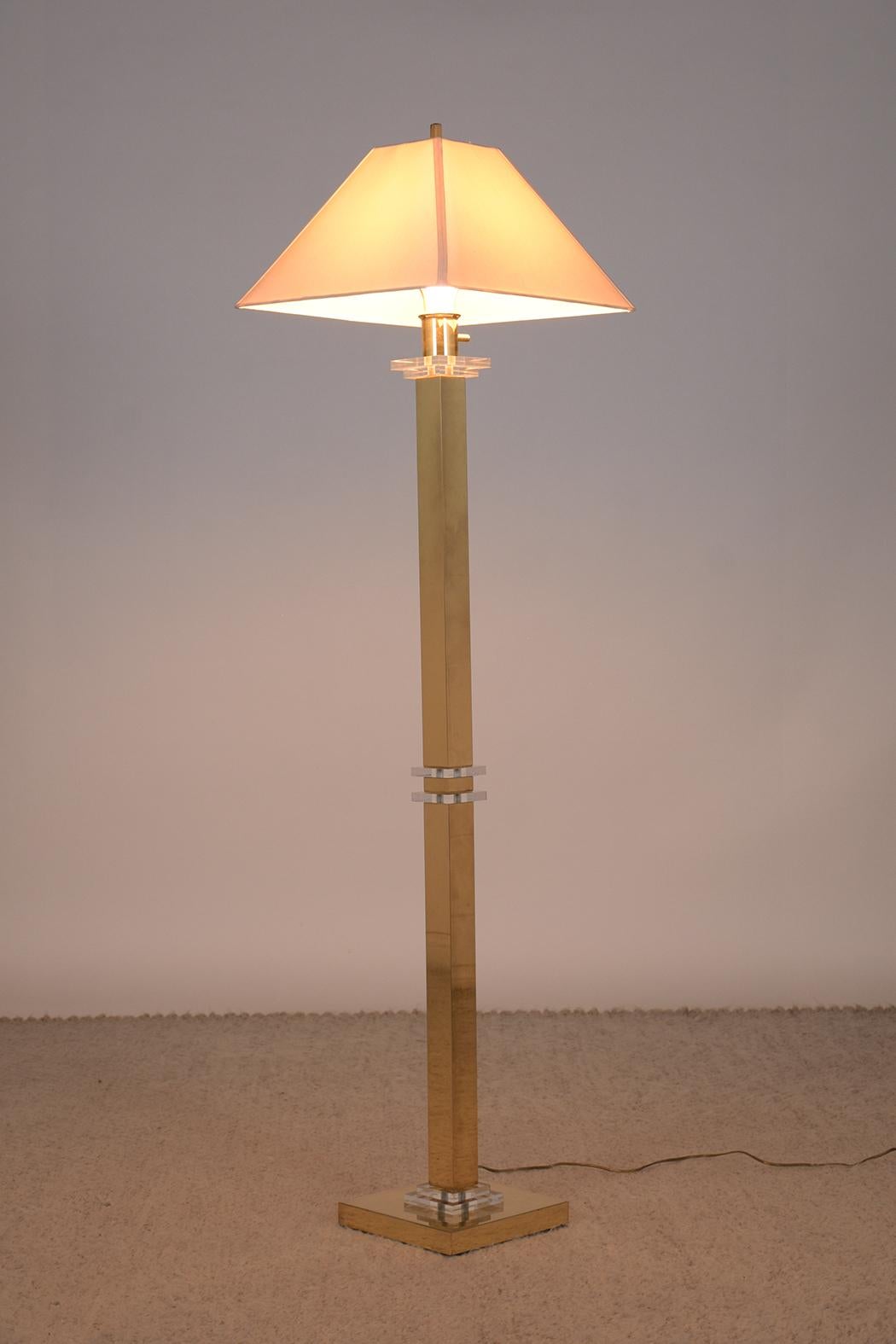 Illuminate your living space with the timeless elegance of our Mid-Century Modern floor lamp, a striking combination of brass and lucite. This piece has been hand-crafted with meticulous attention to detail and is in outstanding condition, having
