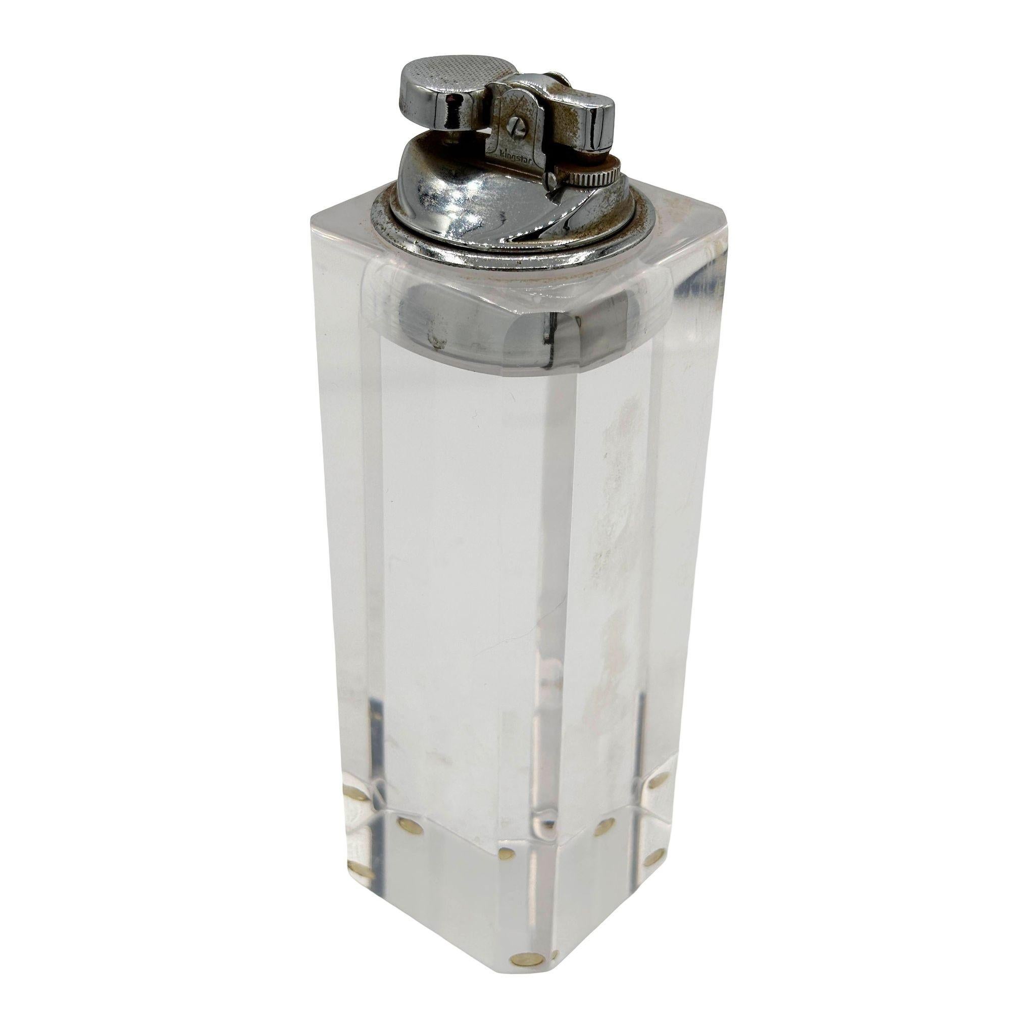 Rare briquet de table en lucite de l'époque du milieu du siècle avec briquet chromé amovible. Le briquet est doté d'un grand bloc sculpté en lucite aux bords arrondis et d'un porte-briquet en acier sur le dessus pour accueillir le briquet en osier