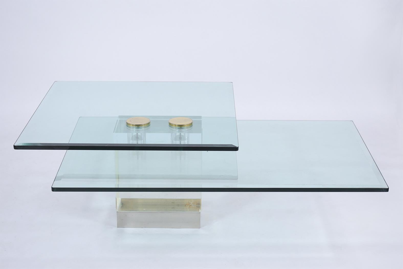An extraordinary modern cocktail table handcrafted out of a combination of steel and glass. This signed coffee table features a two-tier sleek design an original clear glass with a beveled edge, This coffee table is eye-catching sits on a Lucite