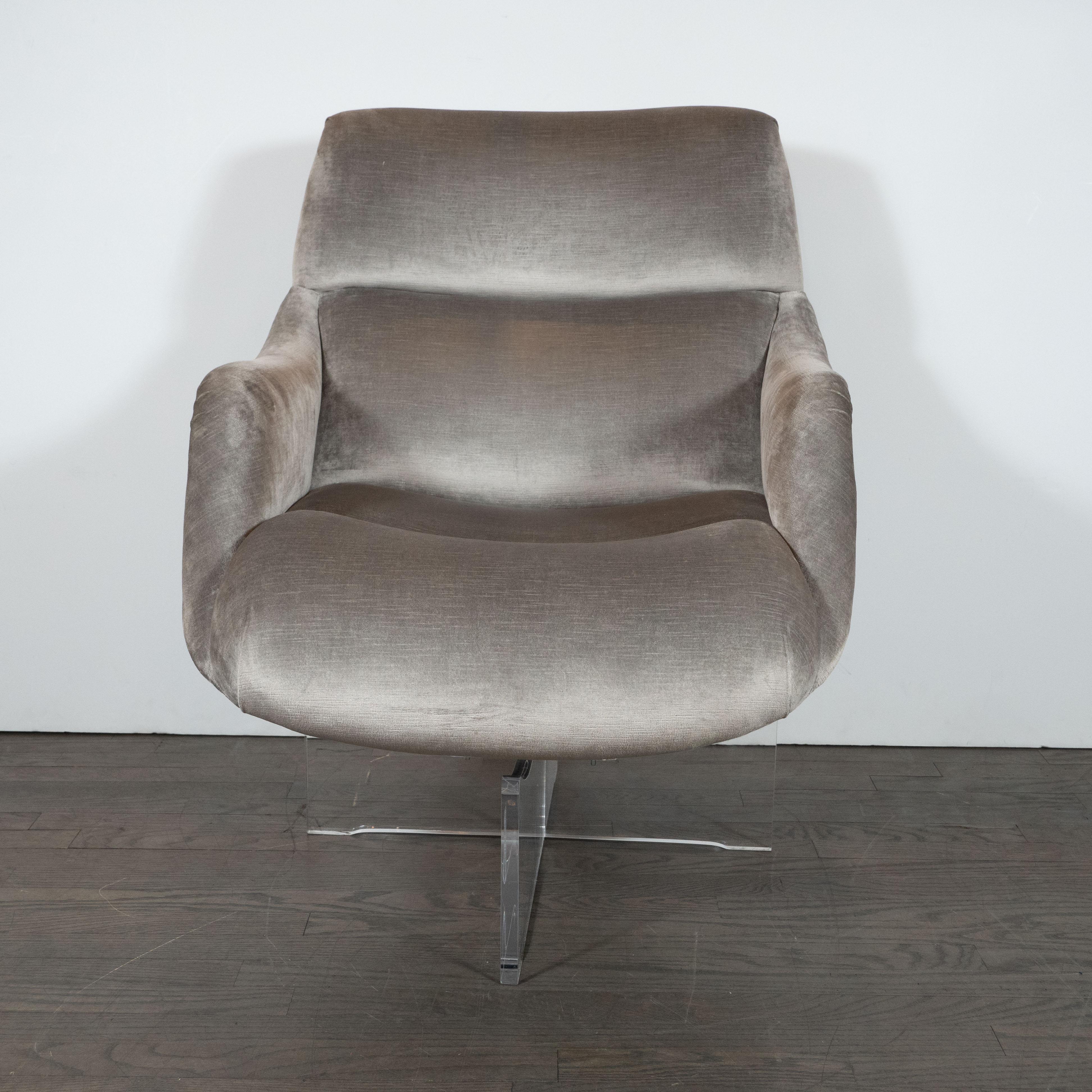 This stunning and iconic pair of swivel lounge chairs were designed by Vladimir Kagan and hand fabricated in the United States, circa 1970. They chairs feature a sculptural X-form base in Lucite with subtly bowed tops; sinuously curved arm rests;