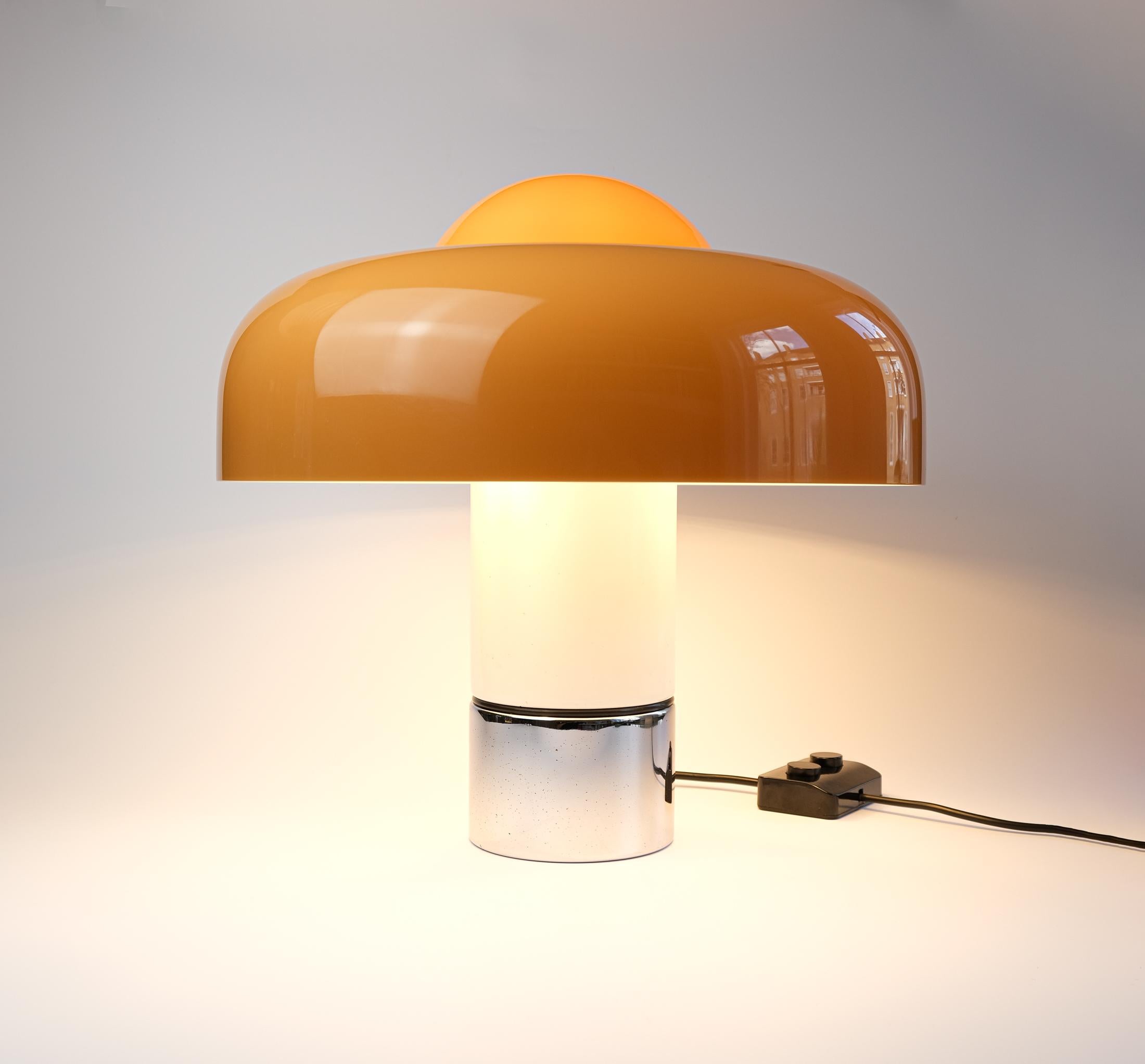 Die hier angebotene Tischleuchte BRUMBURY wurde 1969 von Luigi Massoni für Harvey Guzzini entworfen - ein herausragendes Stück aus dem goldenen Zeitalter des italienischen modernen Designs. Mit ihrem kuppelförmigen Acryldiffusor und dem eleganten