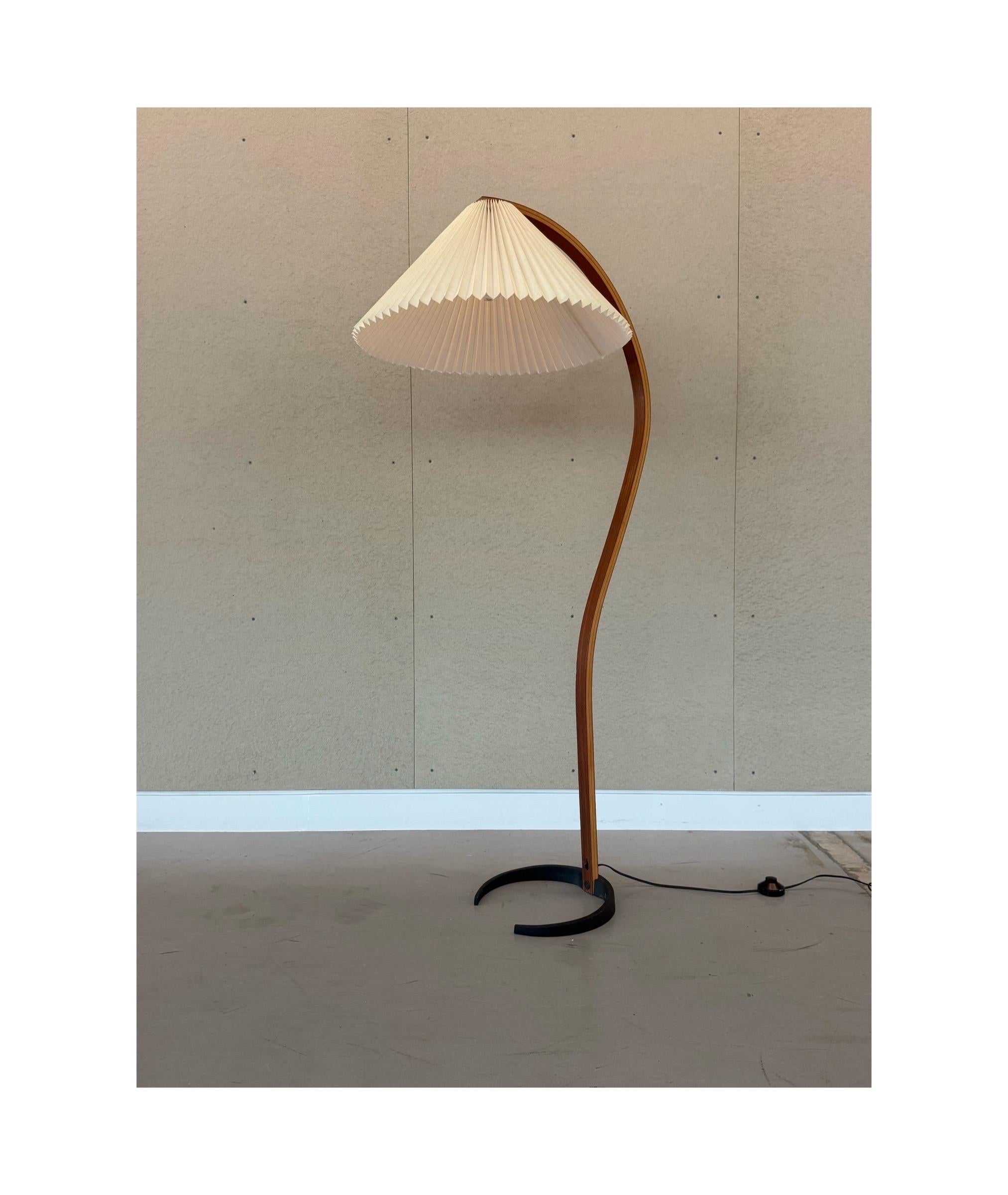 Mid-century floor lamp designed by Caprani Light AS, circa 1970s. A crescent cast iron base is sleek and keeps the lamp standing study. Original Caprani emblem found on the crescent base. The stem is bentwood beech that showcases an organic shape