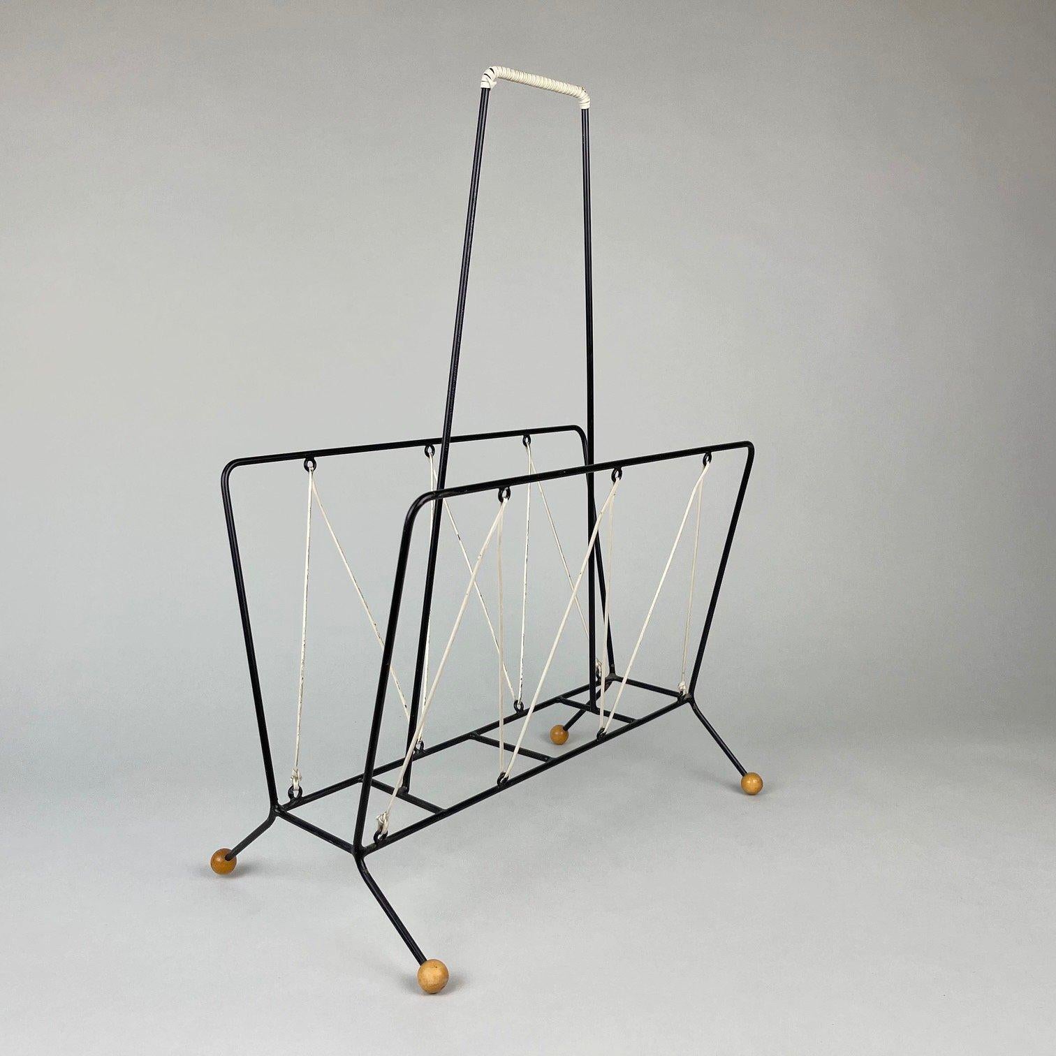 Vintage metal magazine rack intertwined with a rubber cord.