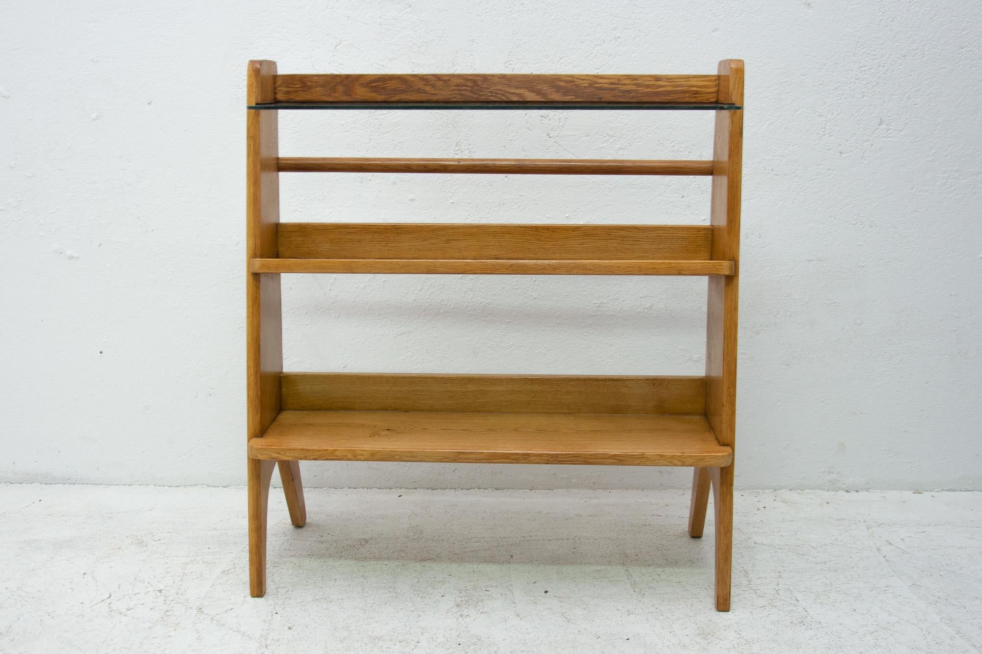 Lovely midcentury wooden magazine stand or rack with one glass shelf and two wooden shelves. It was made for Krásná Jizba dp, Praha(Prague).
It can also be used as a small library etc.
It's made of beechwood.
In very good vintage condition