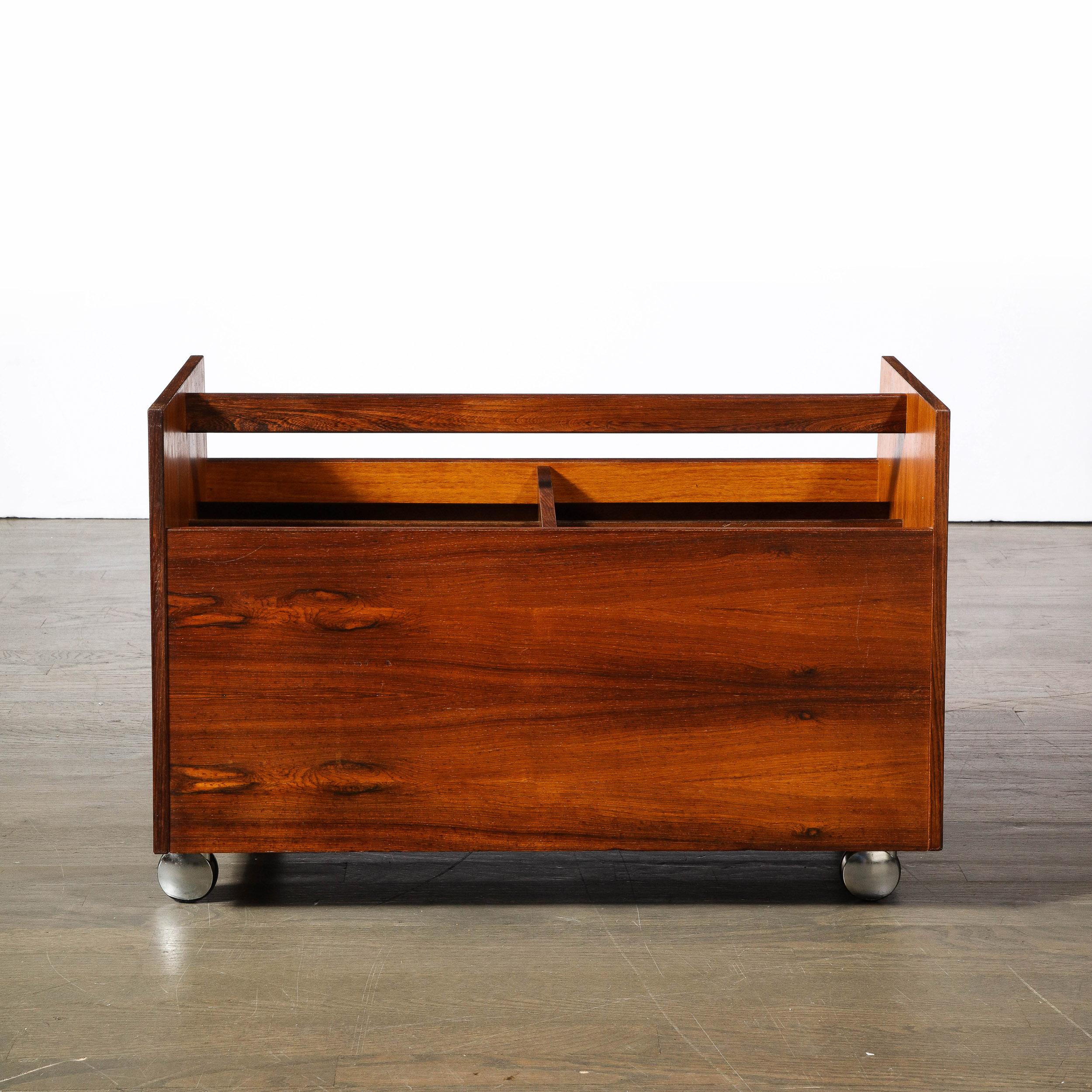 This breathtaking Mid-Century Modernist Magazine Rack in Book-matched Rosewood is designed by the esteemed artist Rolf Hesland for Bruksbo, originating from Norway, Circa 1960. Hesland trained as a furniture maker in Norway and later studied at the