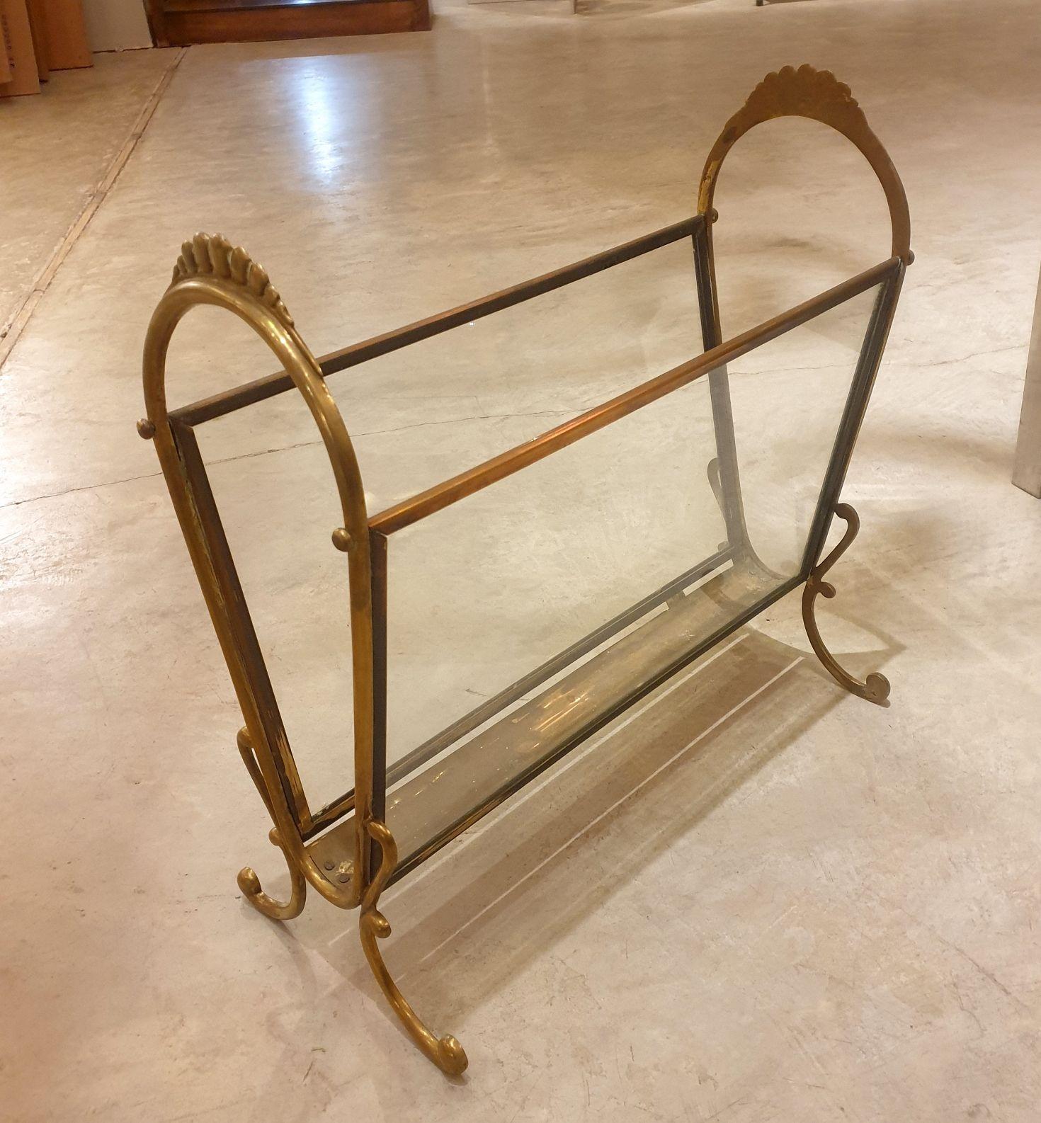 Revistero moderno de mediados de siglo, Italia años 50.
La estantería vintage está fabricada con soportes de latón y laterales de cristal.
El diseño es sencillo y elegante.
Bonita pátina en el latón: normal con la edad.
Excelente estado.