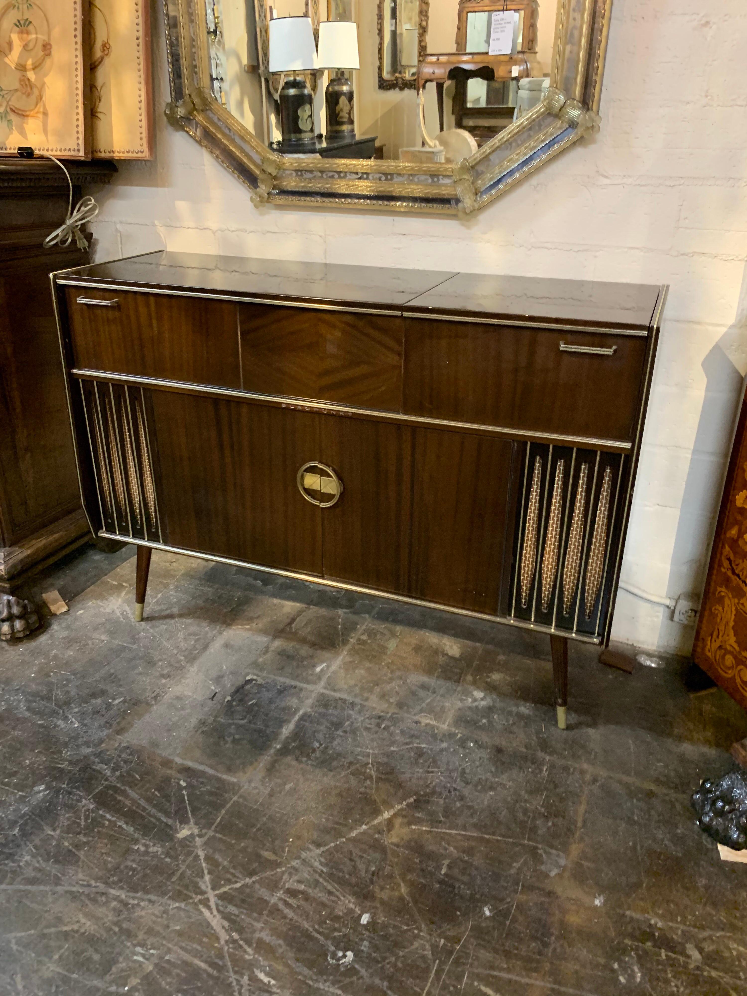 Very handsome midcentury mahogany and brass record console by Blaupunkt. Beautiful polish on this cabinet and the turntable is still in the cabinet. A fun piece that is a real blast from the past!