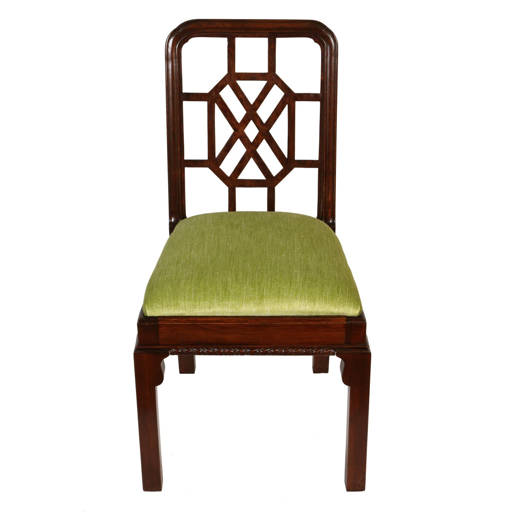 A set of twelve mid century mahogany Chippendale fretwork dining chairs, two armchairs and ten side chairs. Newly upholstered with light green velvet seat cushions. Armchairs measure 23