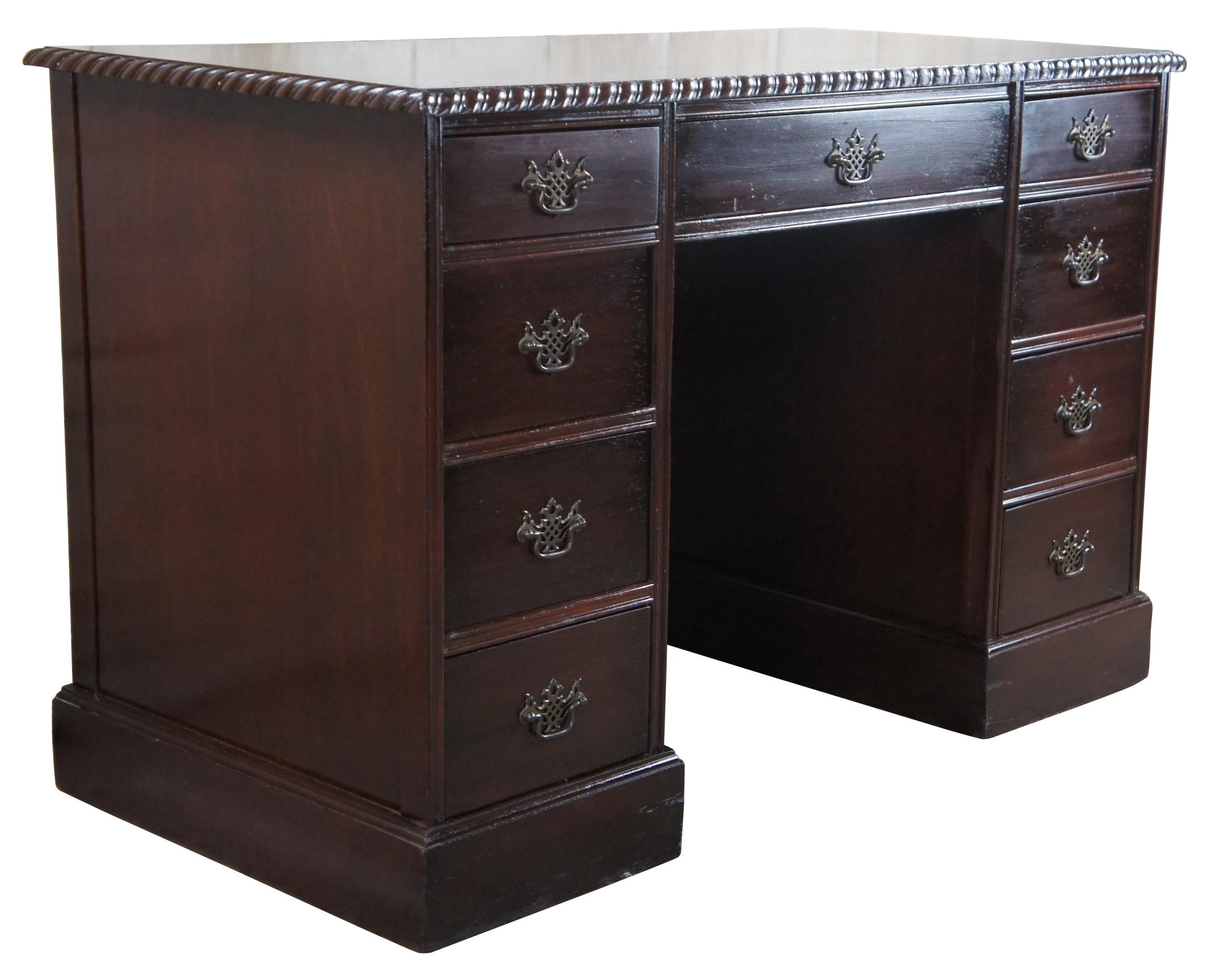 A beautiful mid century kneehole writing desk, circa 1940s. Rectangular form made from mahogany with seven dovetailed drawers and ornate Chippendale style hardware. Features an eye catching gadrooned edge. Finished along all sides allowing for