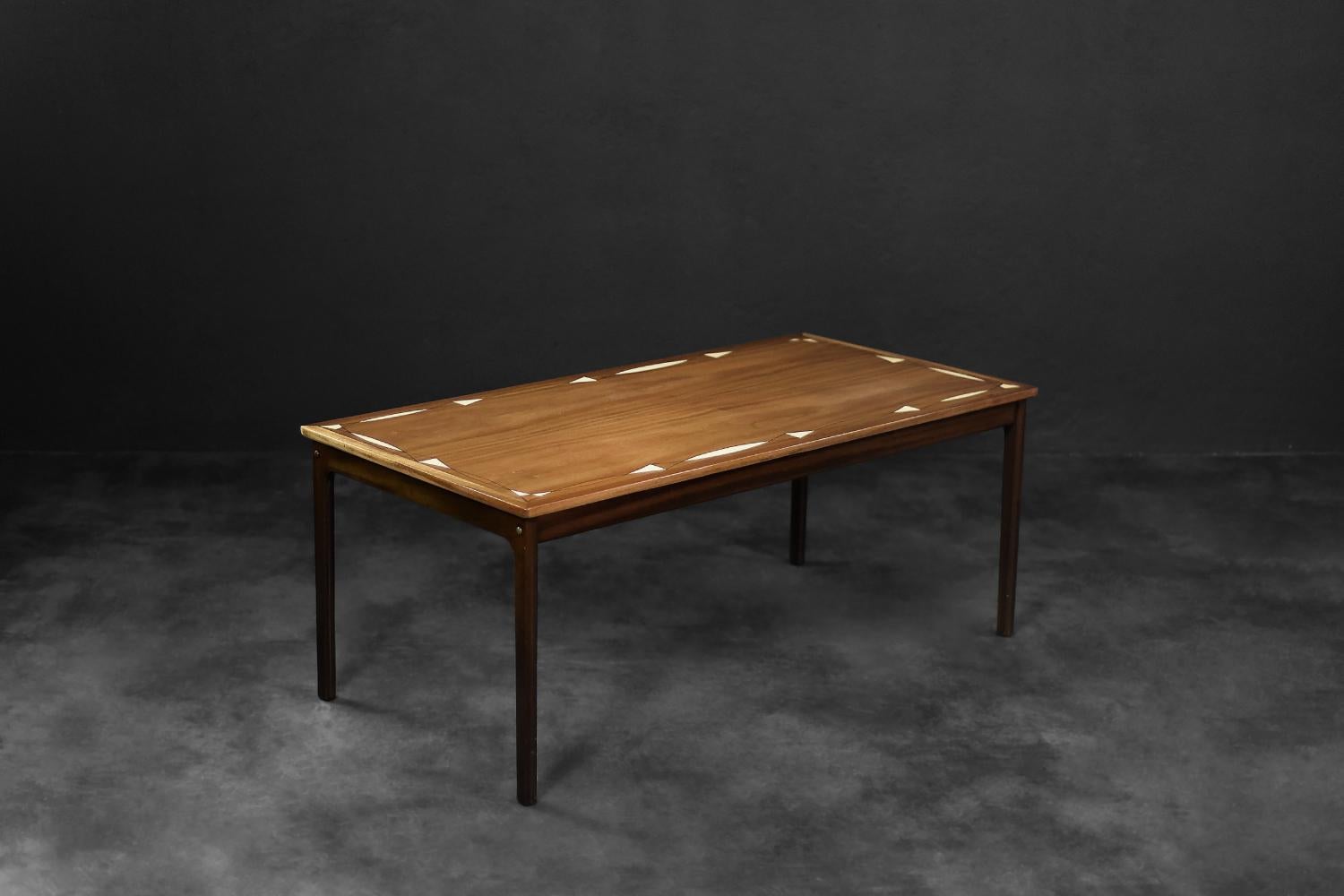 Das Gestell dieses Tisches ist ein Entwurf von Ole Wanscher für den dänischen Hersteller PJ Møbler. Es wurde in den 1960er Jahren hergestellt. Er ist aus hochwertigem dunklem Mahagoni mit interessanter Maserung gefertigt. Die Tischplatte ist