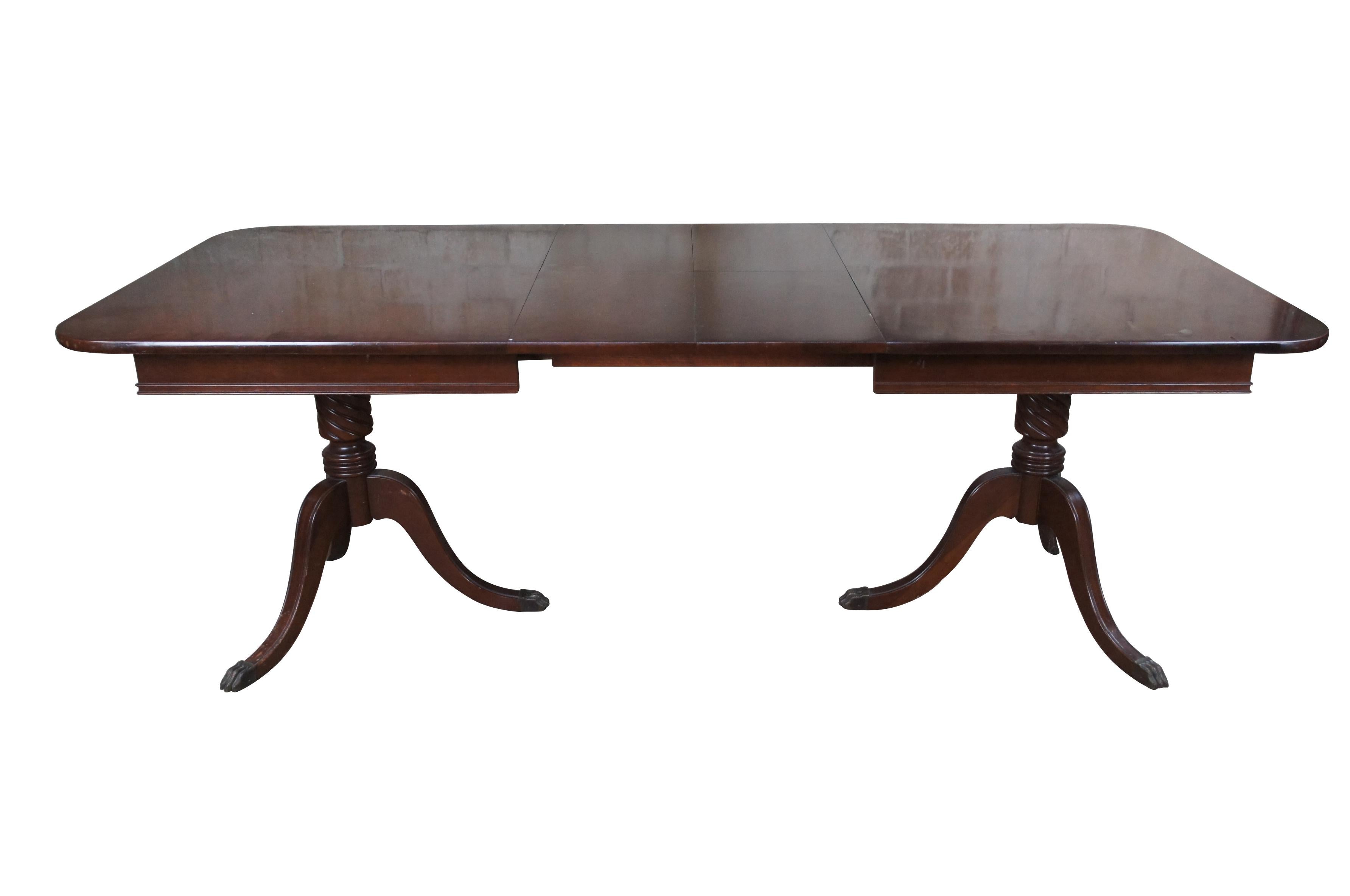 Mid century, circa 1940s, Duncan Phyfe dining table. Made of mahogany featuring rectangular form with built in extendable leaves and two tripod bases that feature barley twisted supports and claw feet.

DIMENSIONS

40
