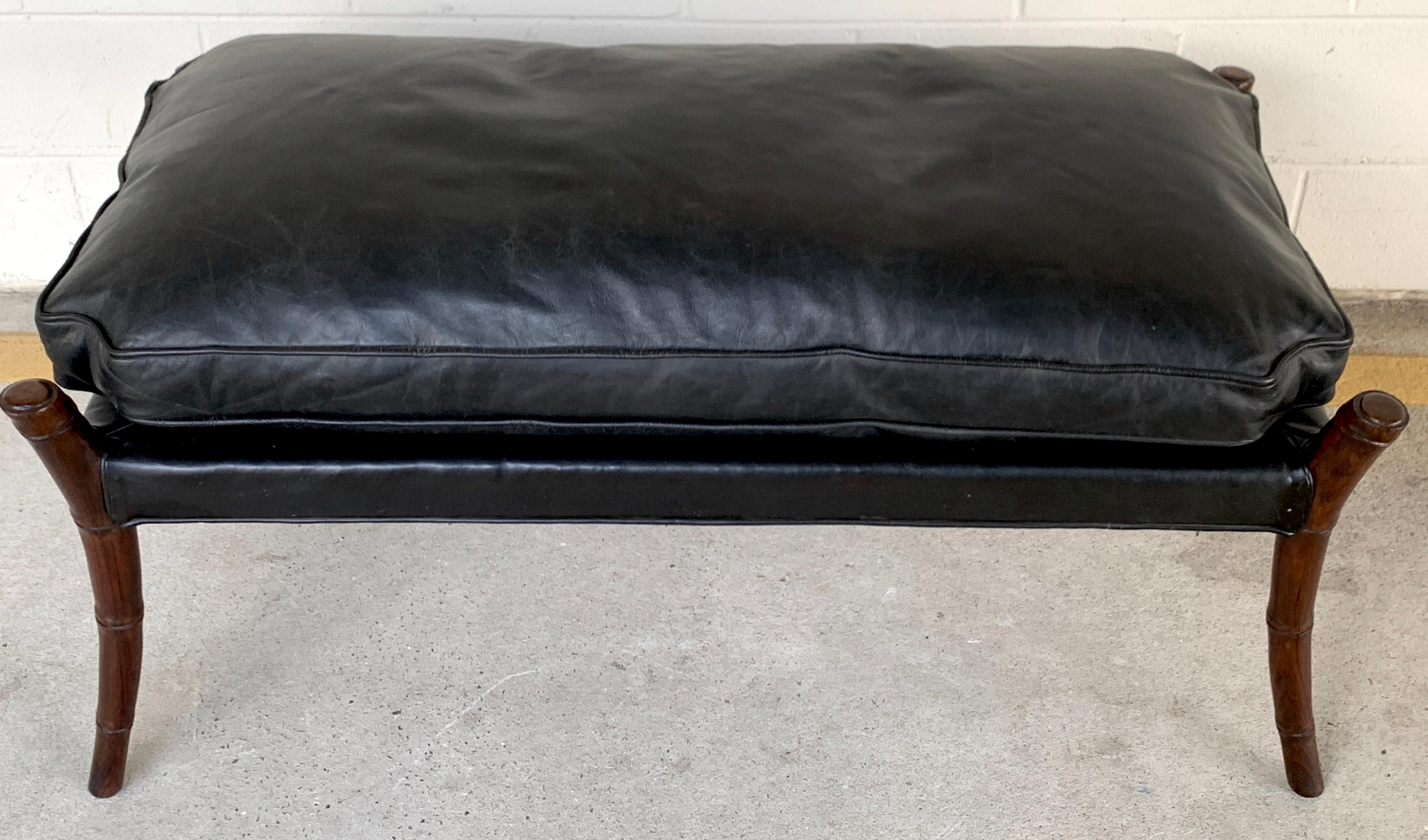 Midcentury mahogany faux bamboo leather bench, upholstered in black leather, with four carved mahogany bamboo legs. The bench seat height with cushion is 19.5 inches high, with no cushion 16.5 inches high.
       