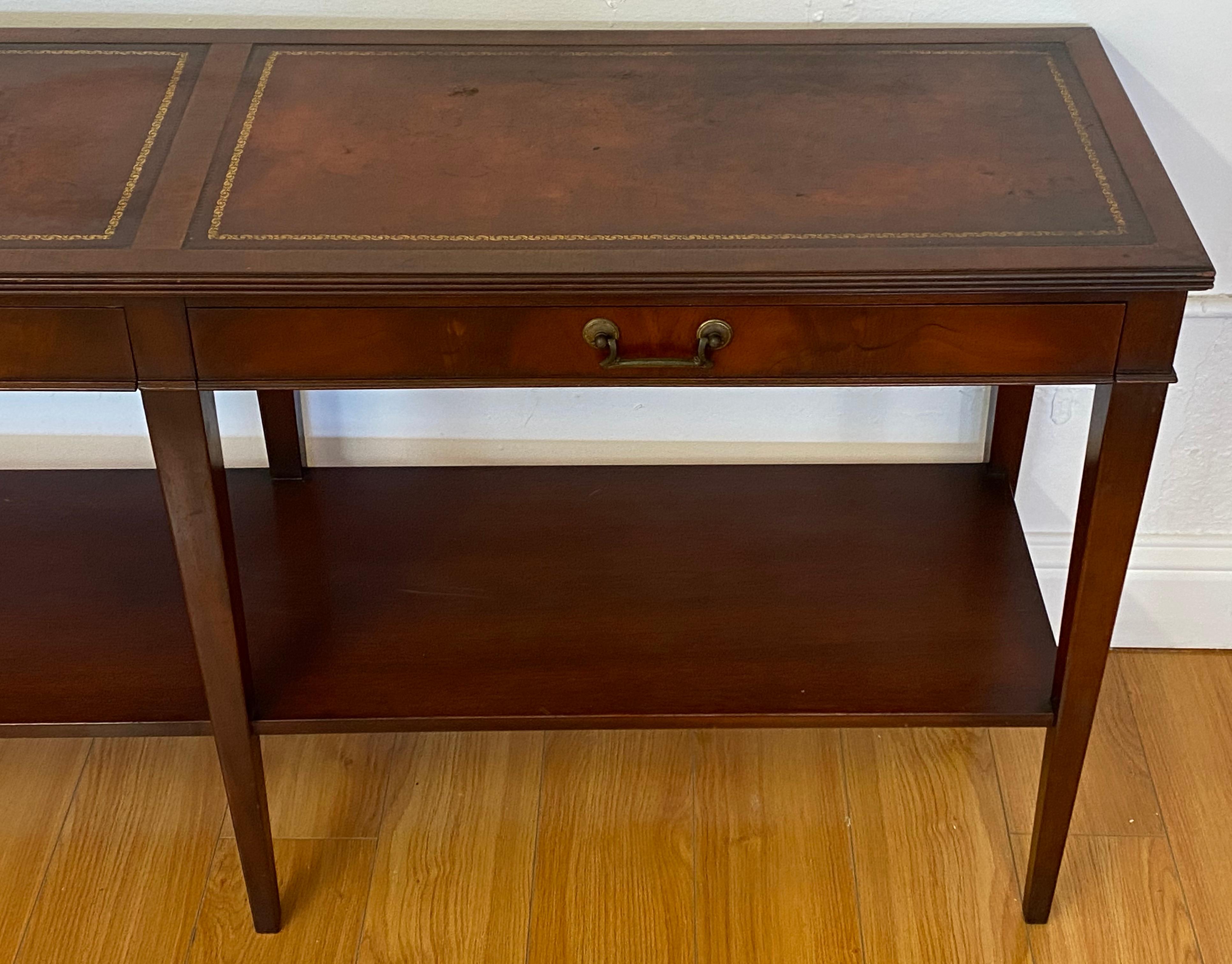 Mid century mahogany two drawer console table by W & J Sloan 

Two drawers under embossed leather panels

The leather shows some distress, but still looks good after 60+ years!

The mahogany frame shows minor loss to the finish - See
