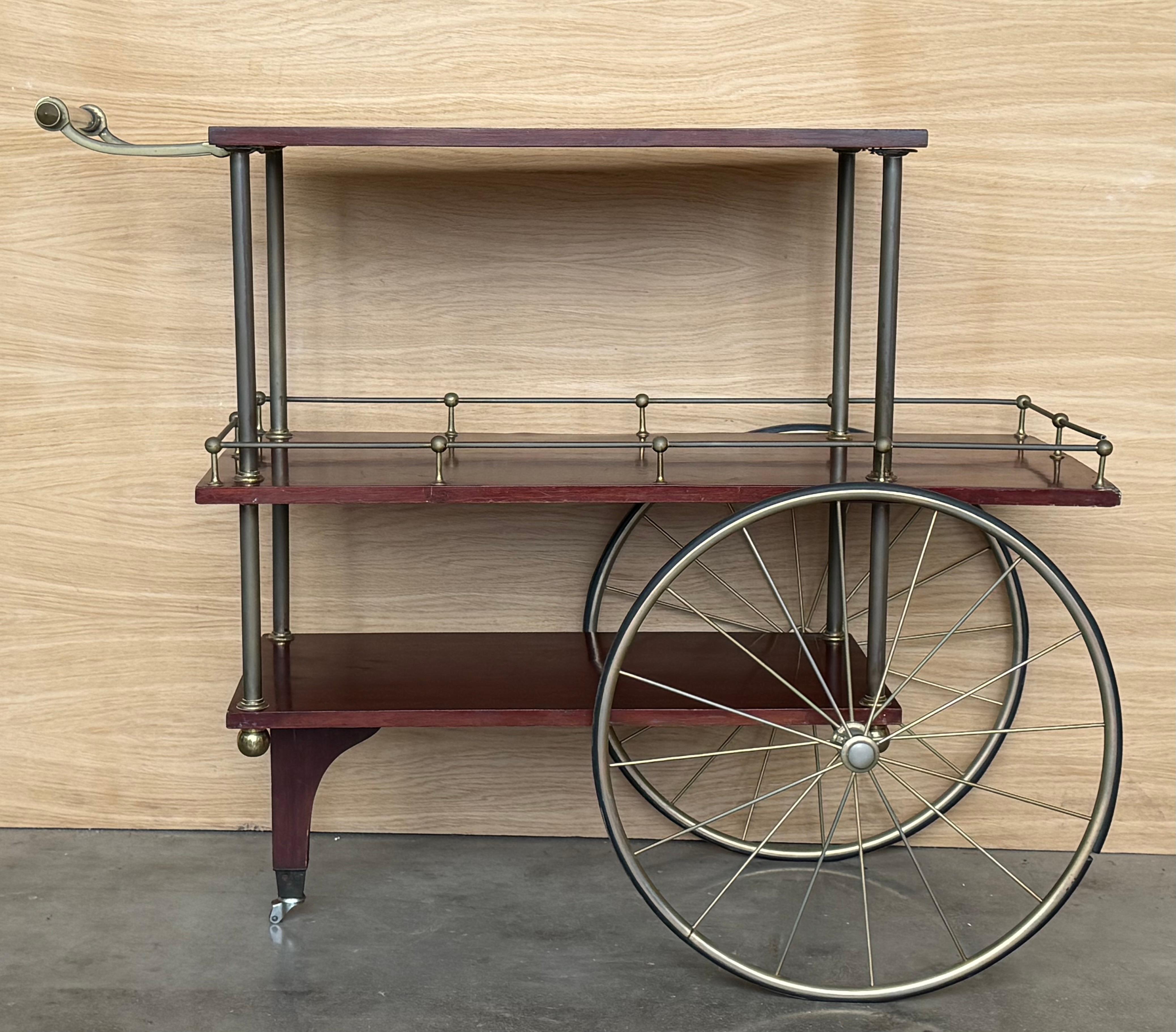 Unique mid-century bar cart in mahogany wood , brass and lucite handle. This fantastic item was designed in Italy during the 1960s.  This magnificent bar cart is amazing because of the shape of the shelves, square on the side near the handle and