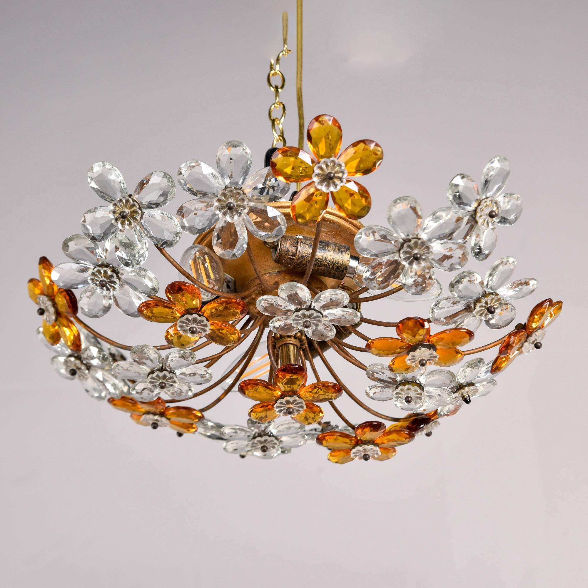 Trouvé en France, ce luminaire encastré dans le style de la Maison Bagues a une base en laiton et en métal doré avec des fleurs en cristal facetté de couleur claire et ambre. Trois prises candélabres. Le câblage a été mis à jour en fonction des