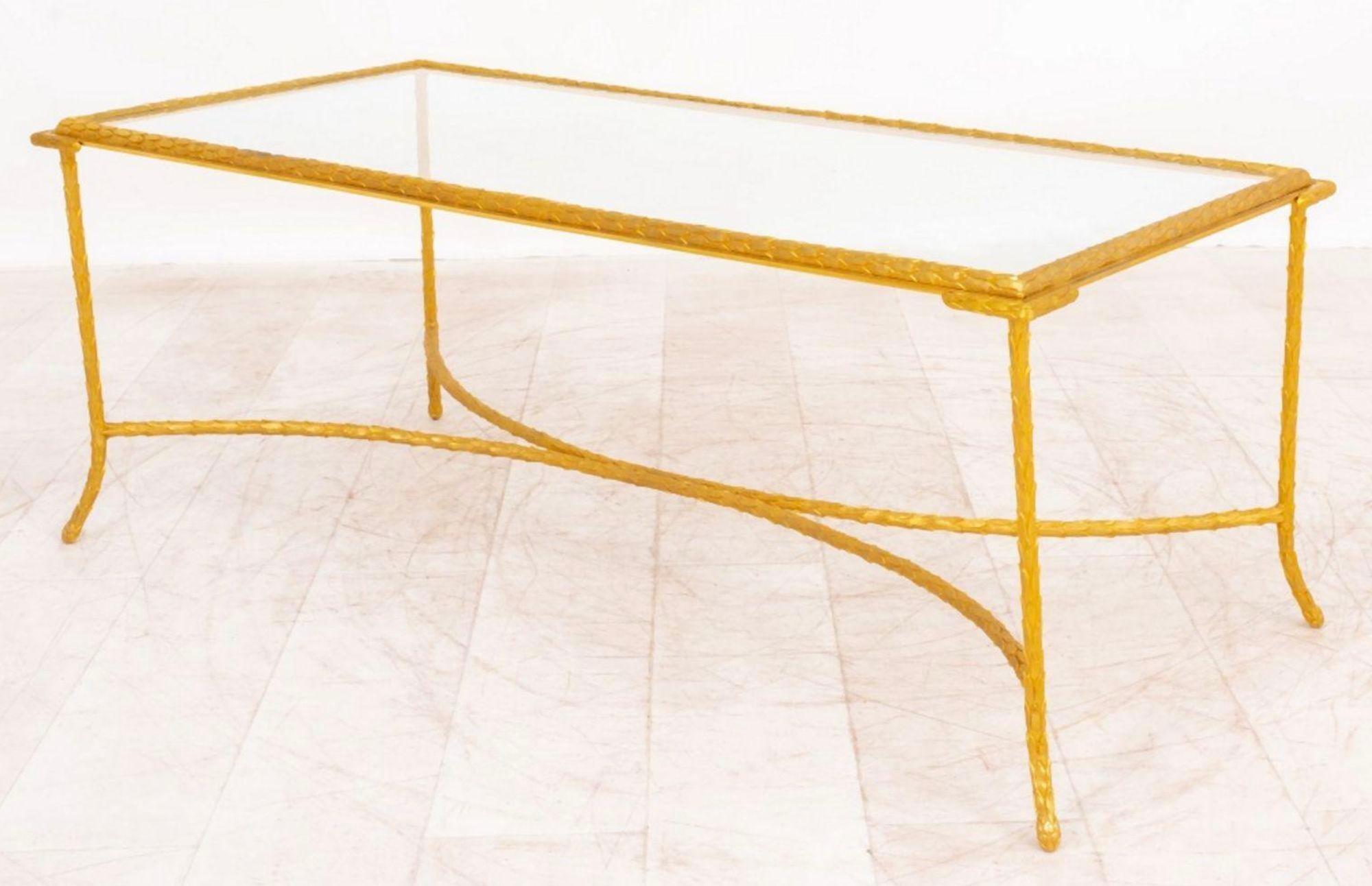 Sleek mid-century low coffee table by Maison Jansen made with rich ormolu and a glass top. The bronze frame is adorned with intricate laurel leafs all around. The table is linked by stretchers at the bottom supporting the table.
Made in France, c.