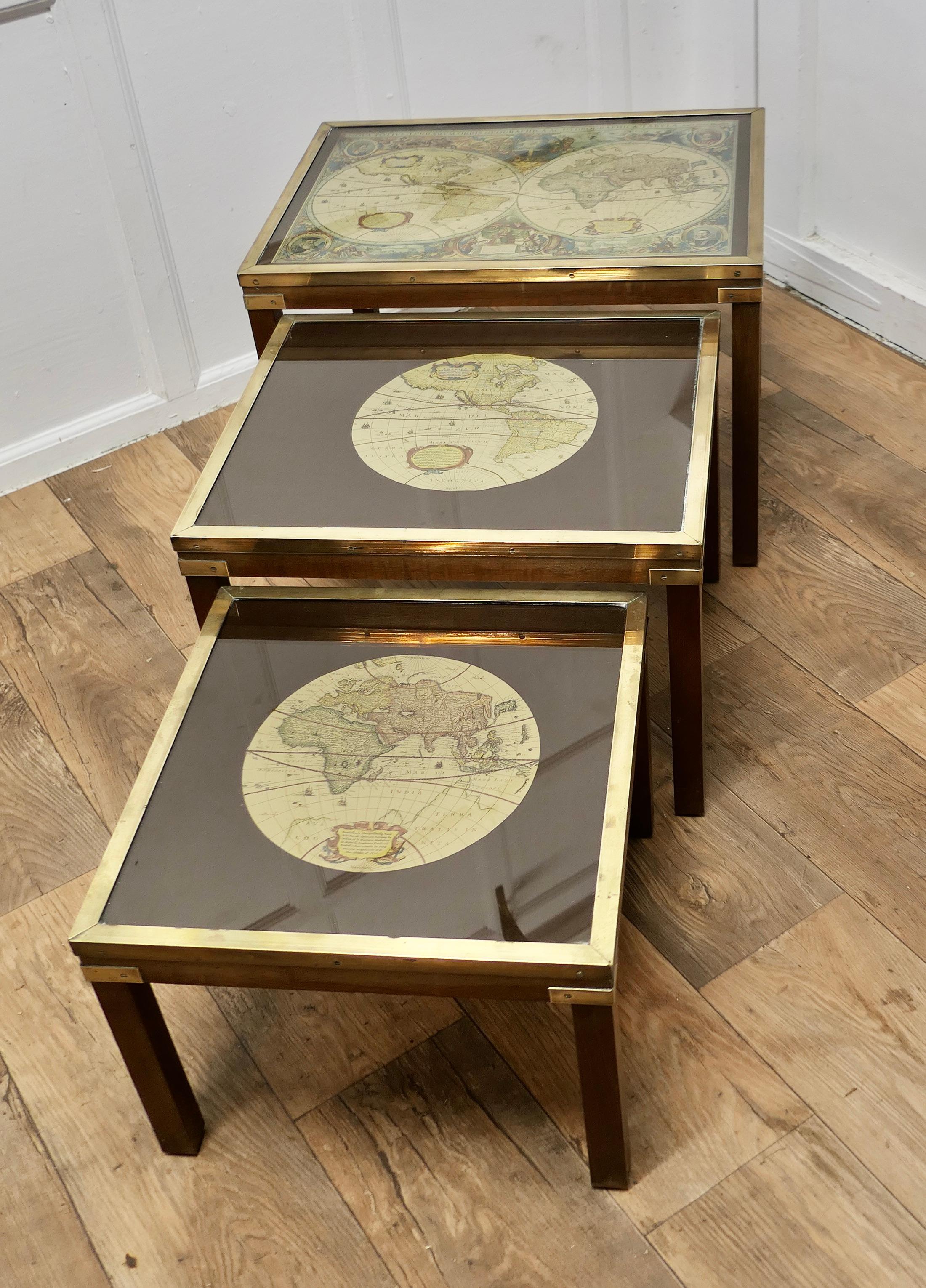 Mid-century Maison Jansen Campaign Style Nest of 3 Tables

Nest of 3 Tables, the table tops have brass trim with brass inlay to the Legs and early world maps on black glass
These are Classic English drawings, this superb classic trio would suit a
